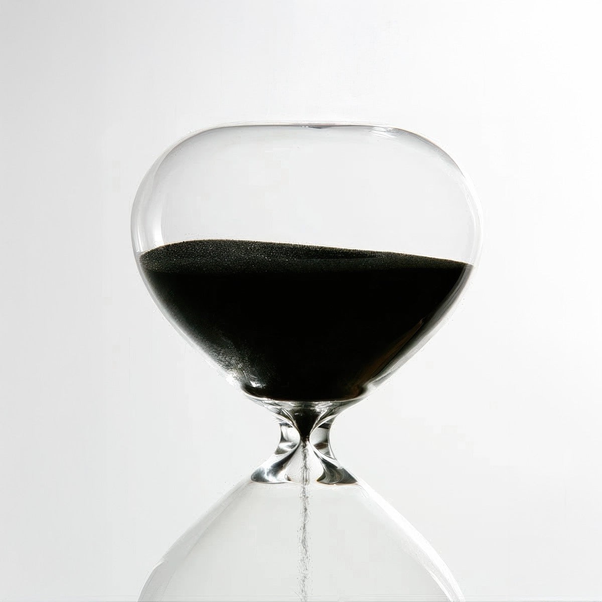 Hourglass with sand running through on a white background