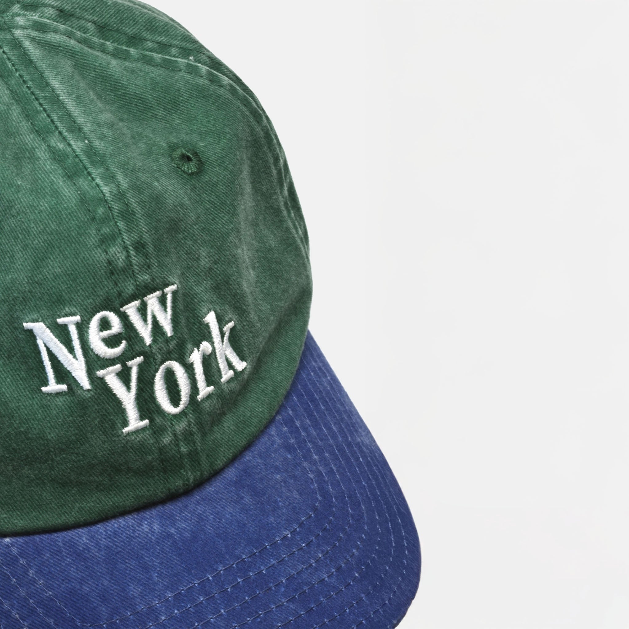Green and blue cap with 'New York' text on a light gray background