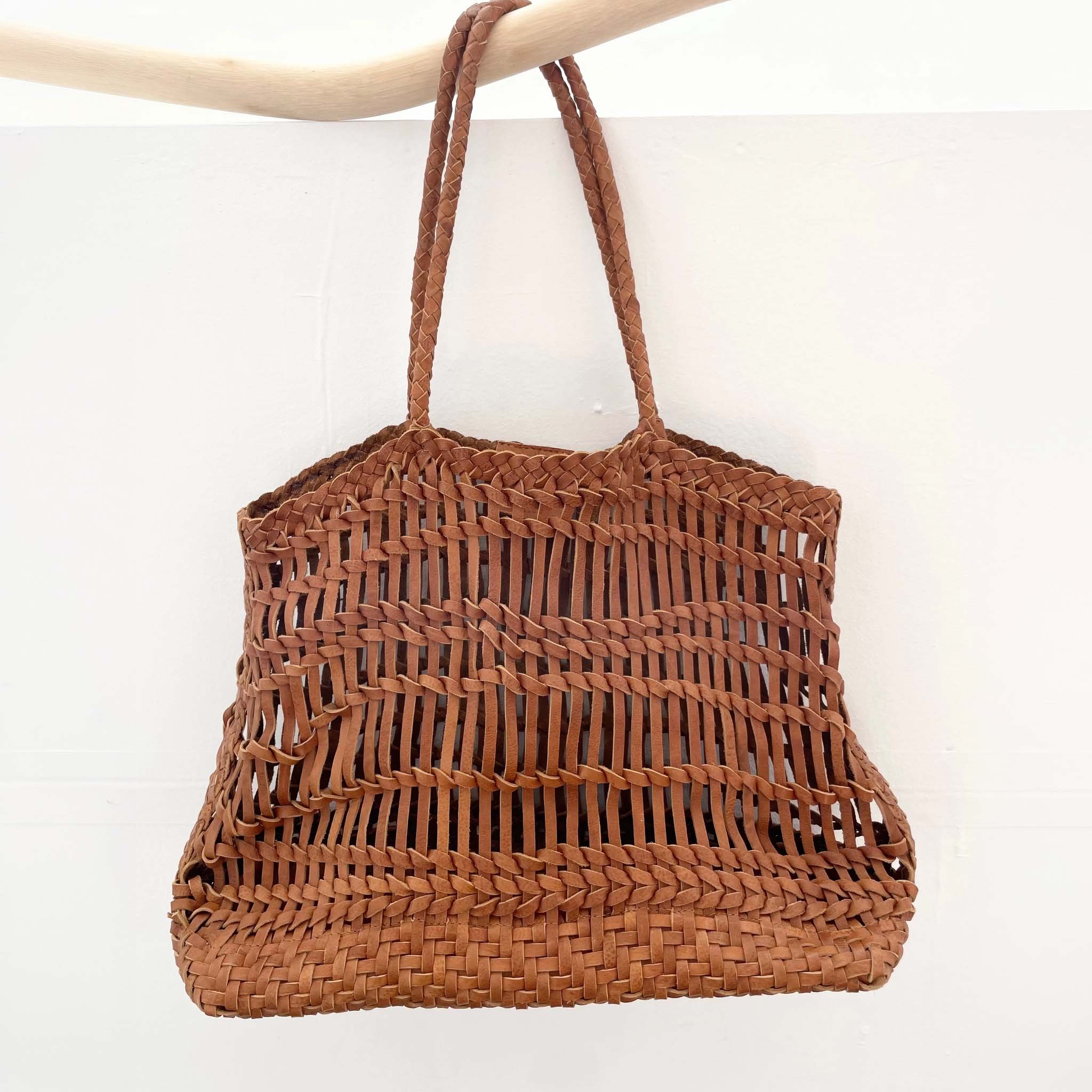 Brown leather woven handbag on a white background