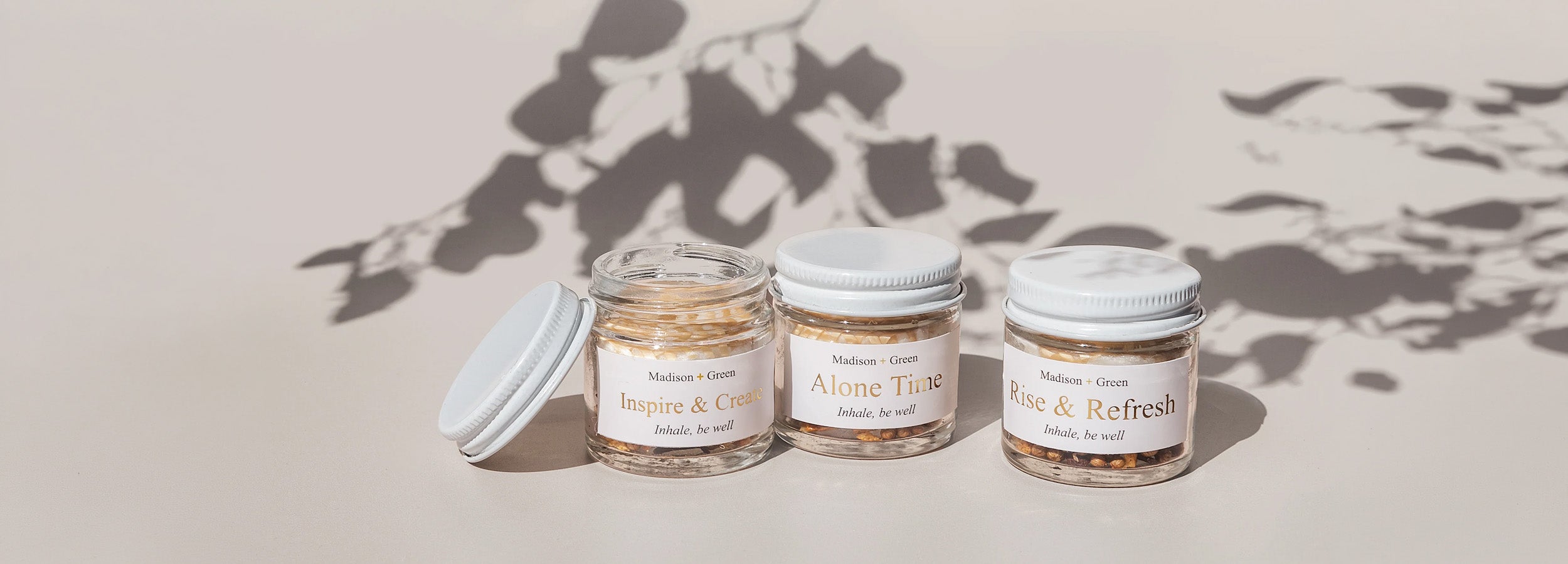 Three jars of aromatherapy inhalers with labels on a light background