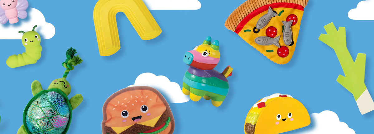 Colorful toy figures of a turtle, hamburger, pizza slice, taco, and caterpillar on a blue background with white clouds.