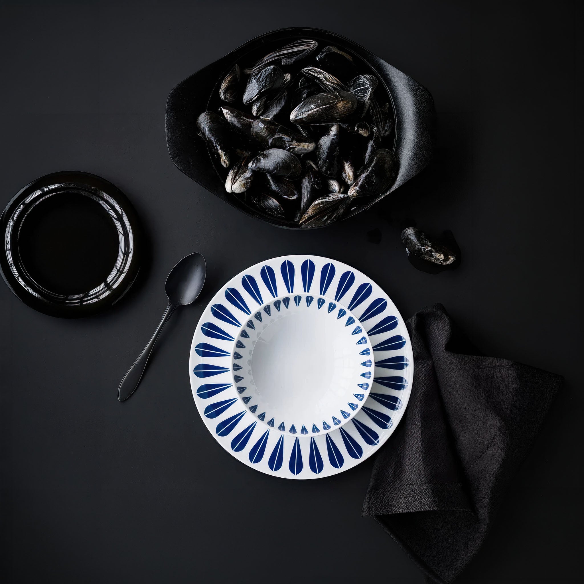 Ceramic plate with blue decorative lotus pattern on a black background