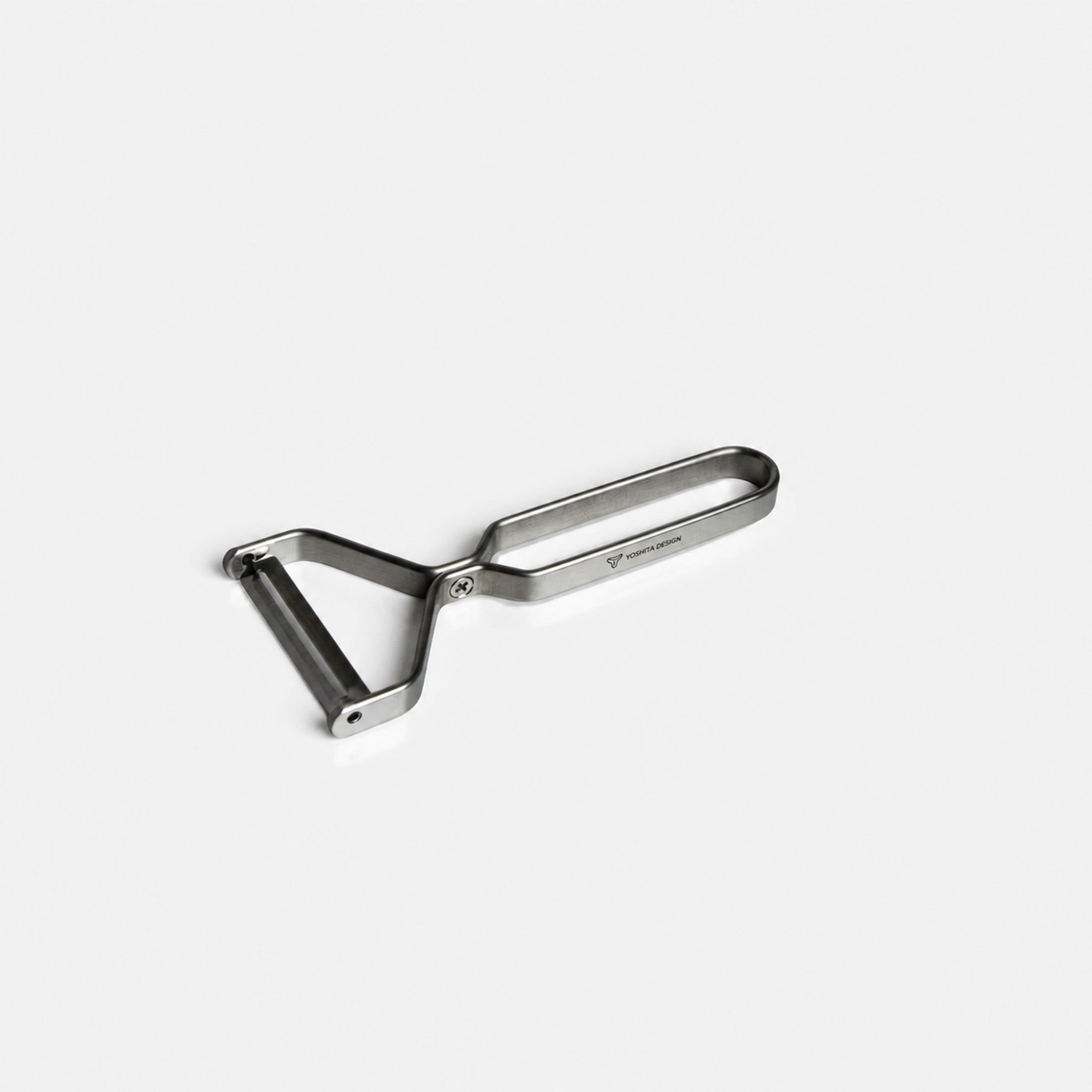 Yoshita stainless steel peeler on a light gray background