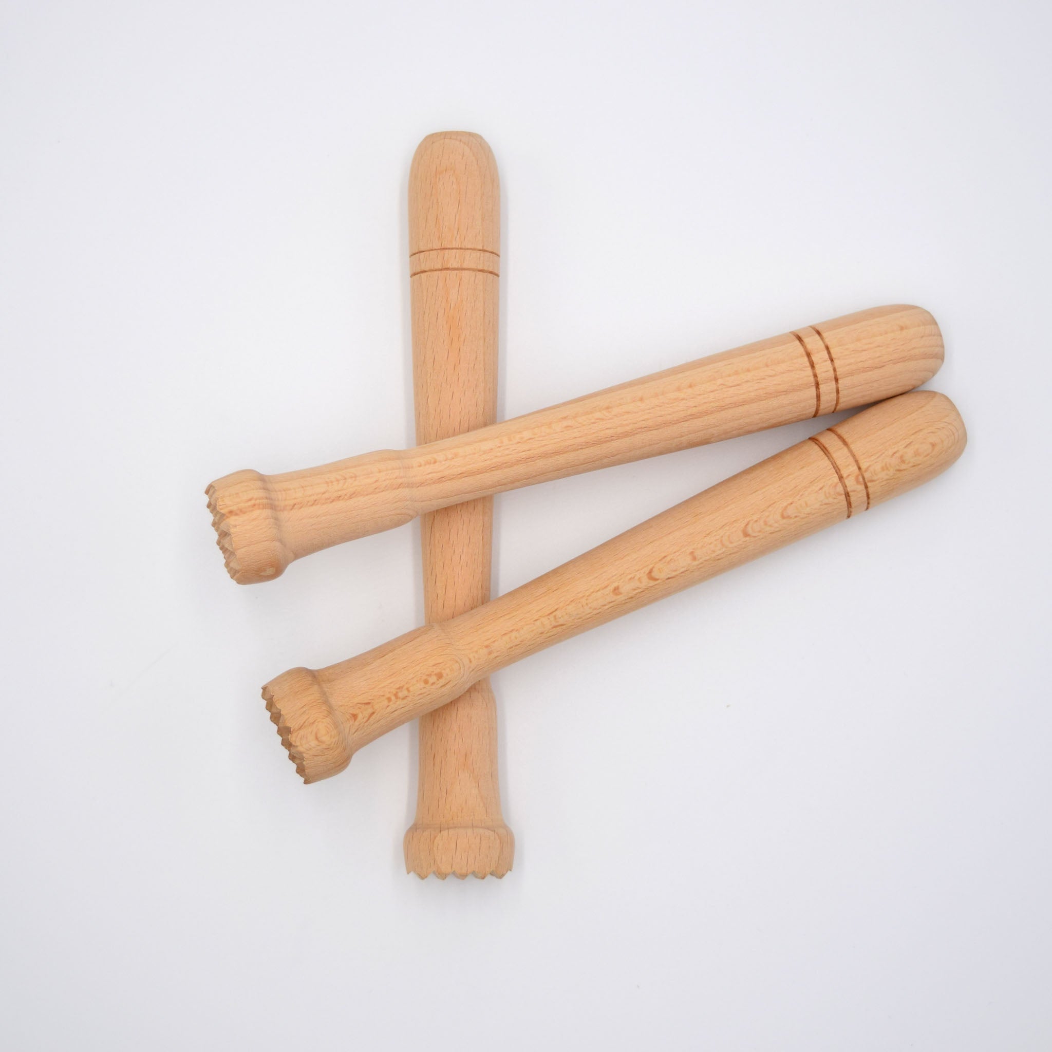 Three wooden muddlers on a white background