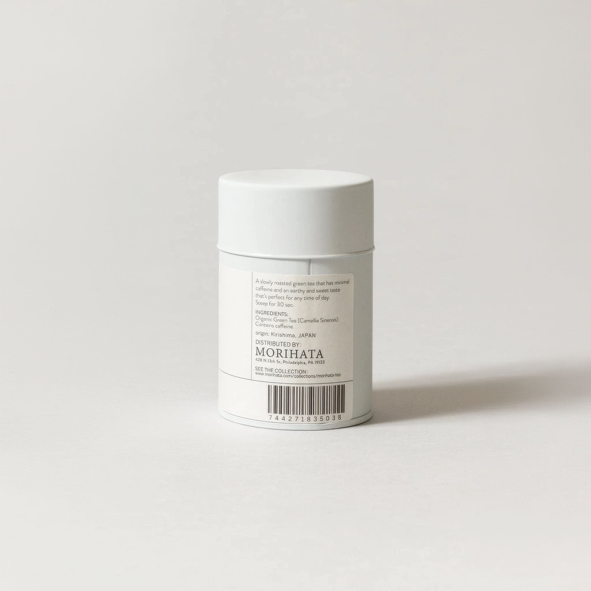 White cylindrical container with a label on a light gray background