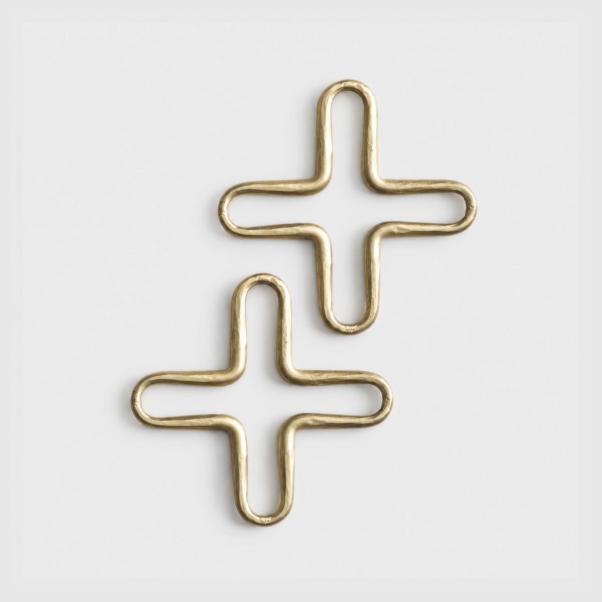 Two brass-toned trivets in a stacked arrangement on a clean white background.