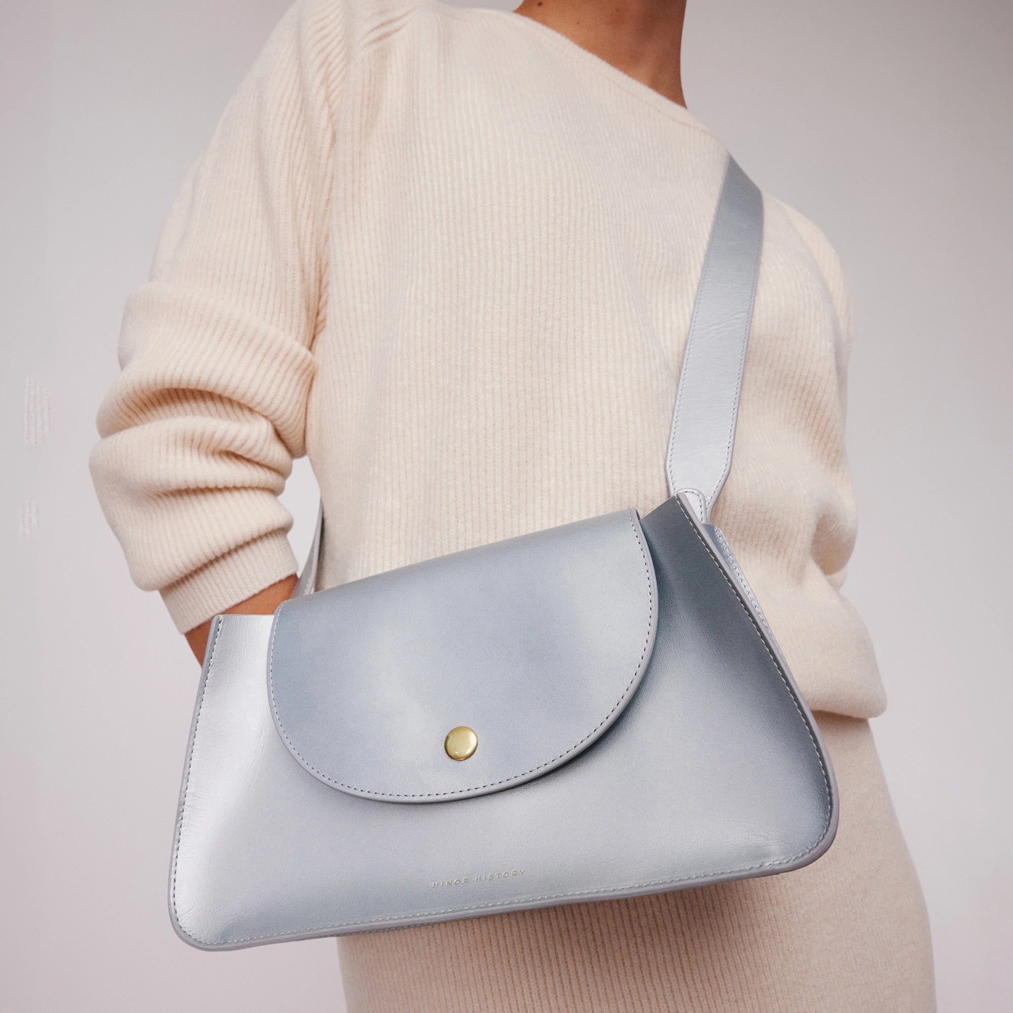 model holding wearing Minor History's The Horizon Crossbody bag sterling over shoulder