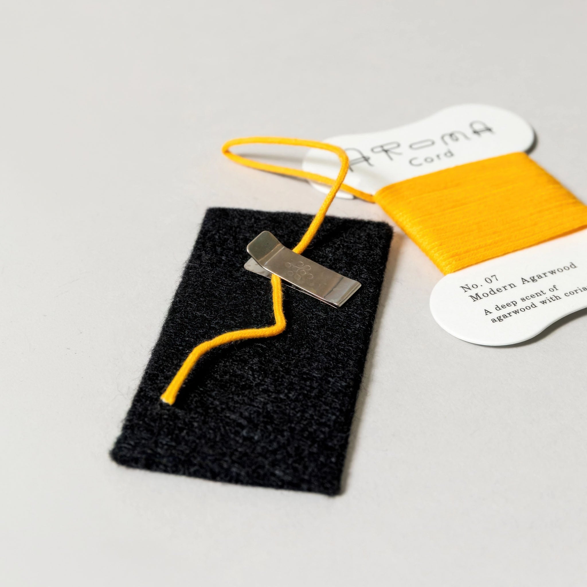 Demonstration of how 'Aroma Cord' No. 07 Modern Agarwood works a light gray background