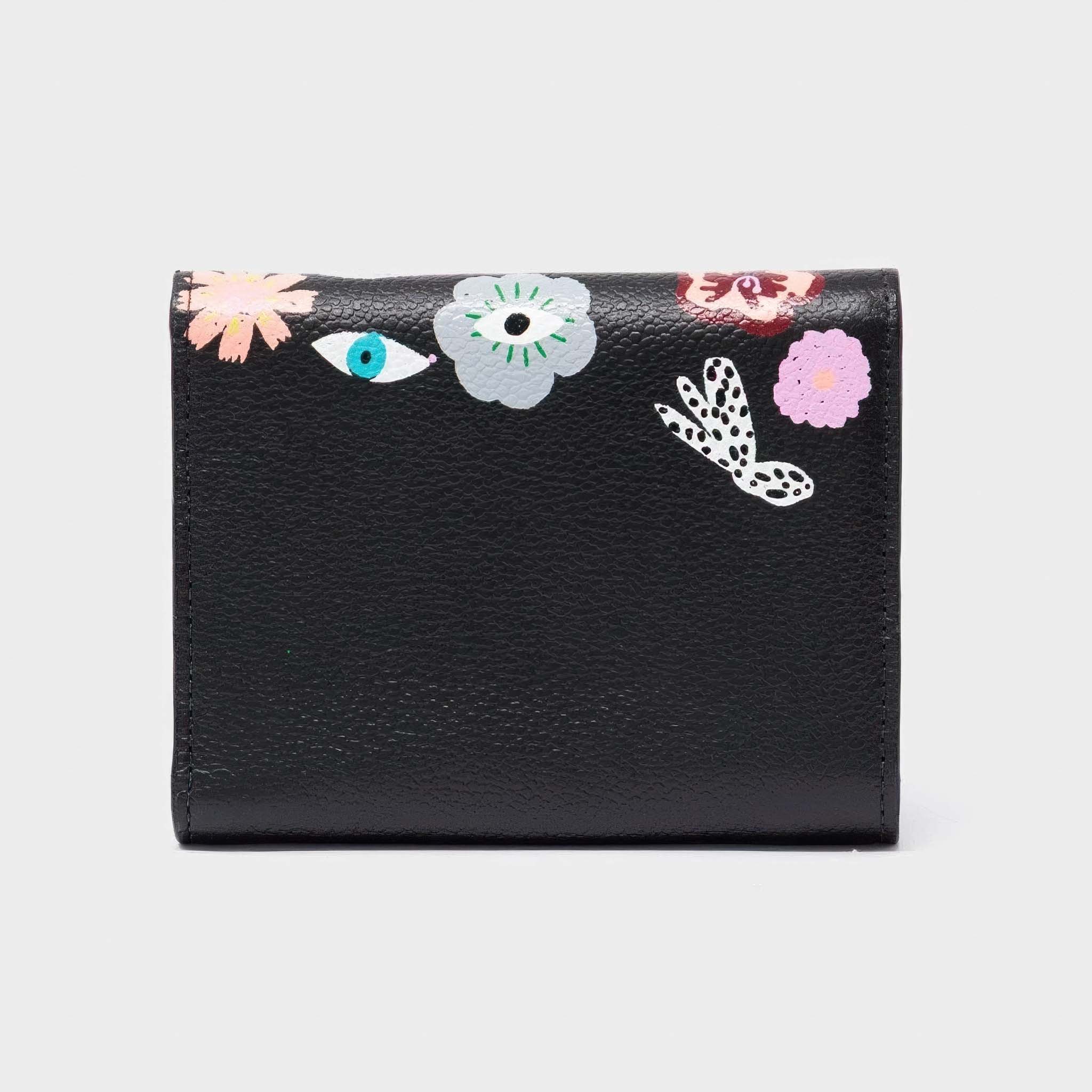 Black wallet with floral and eye designs on a white background