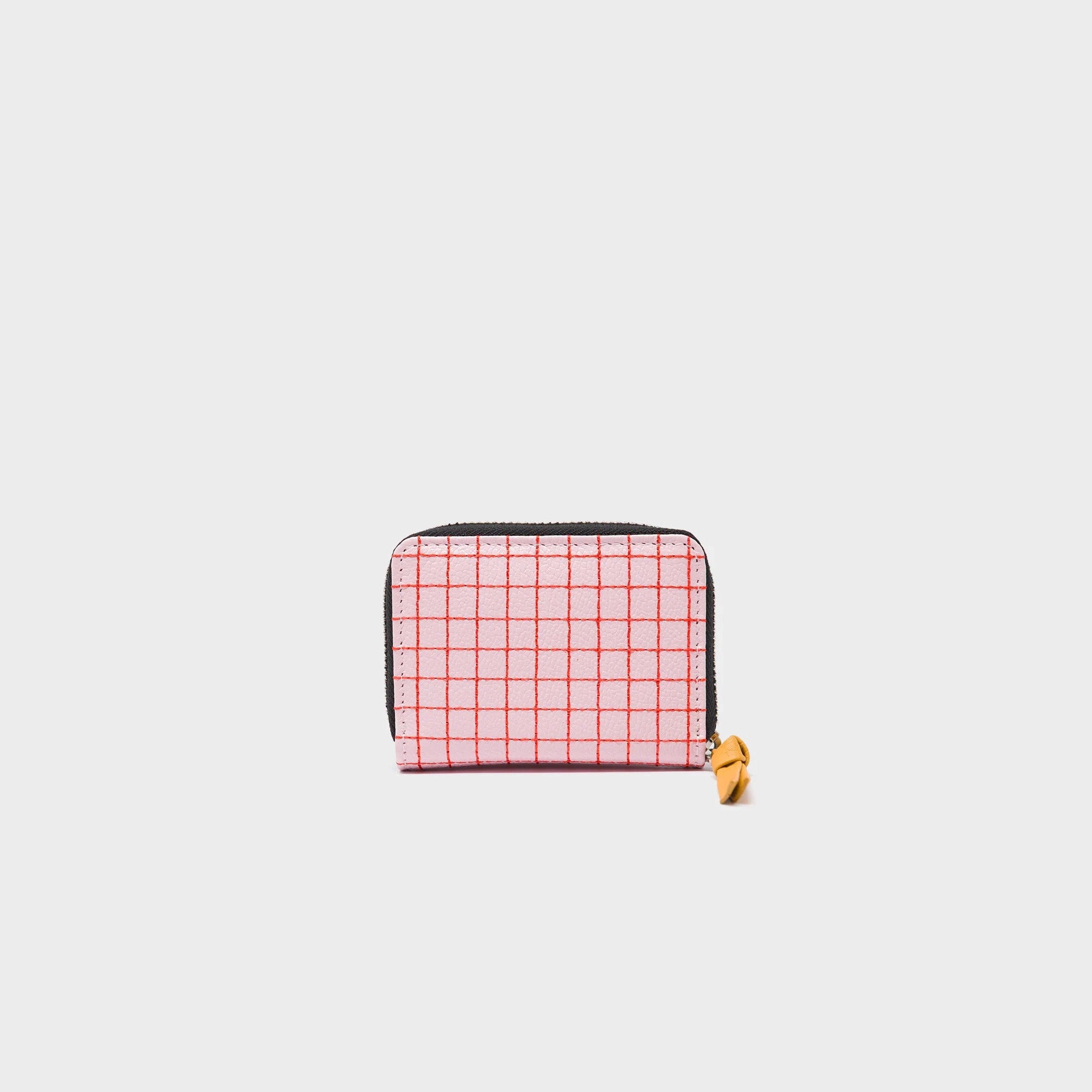 The back of a small wallet with a pink checkered pattern, eye design, and red heart
