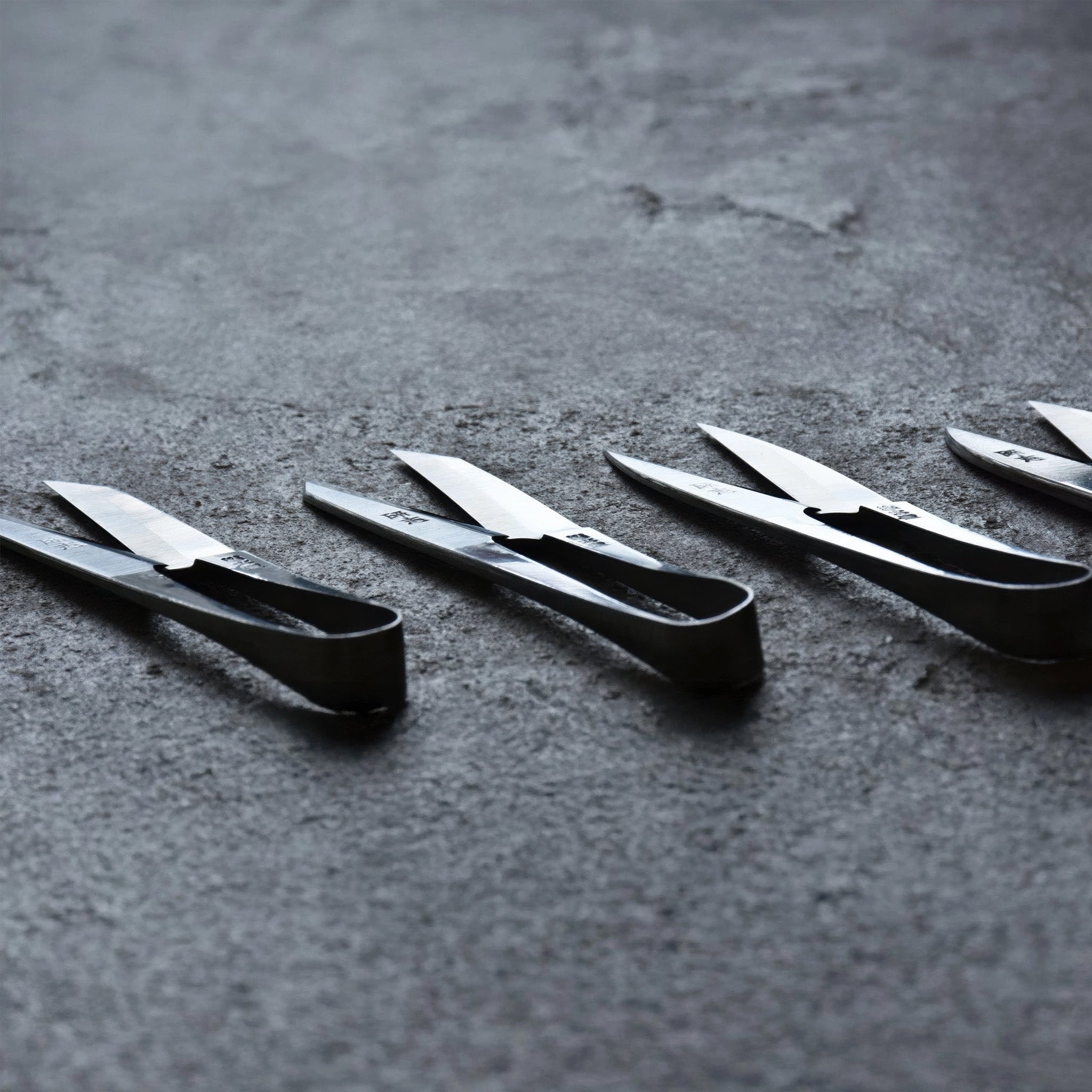 Set of Terazaki Hamono Tsume Scissors on a dark textured surface