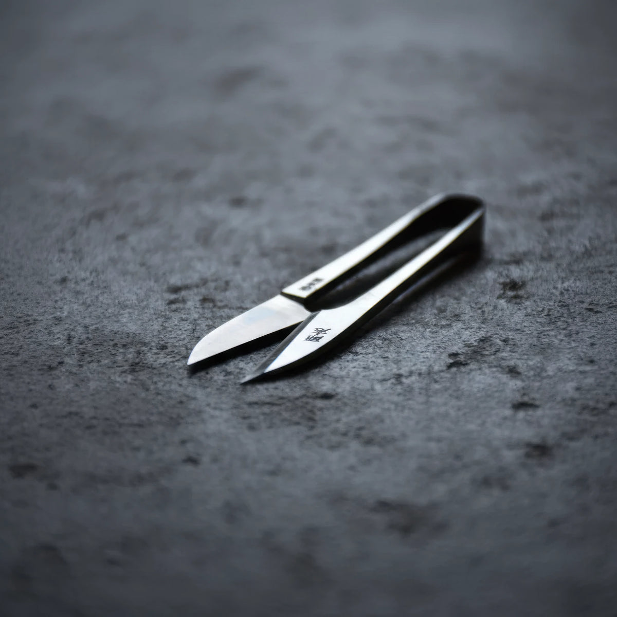 Pair of Terazaki Hamono Tsume Scissors on a dark gray surface