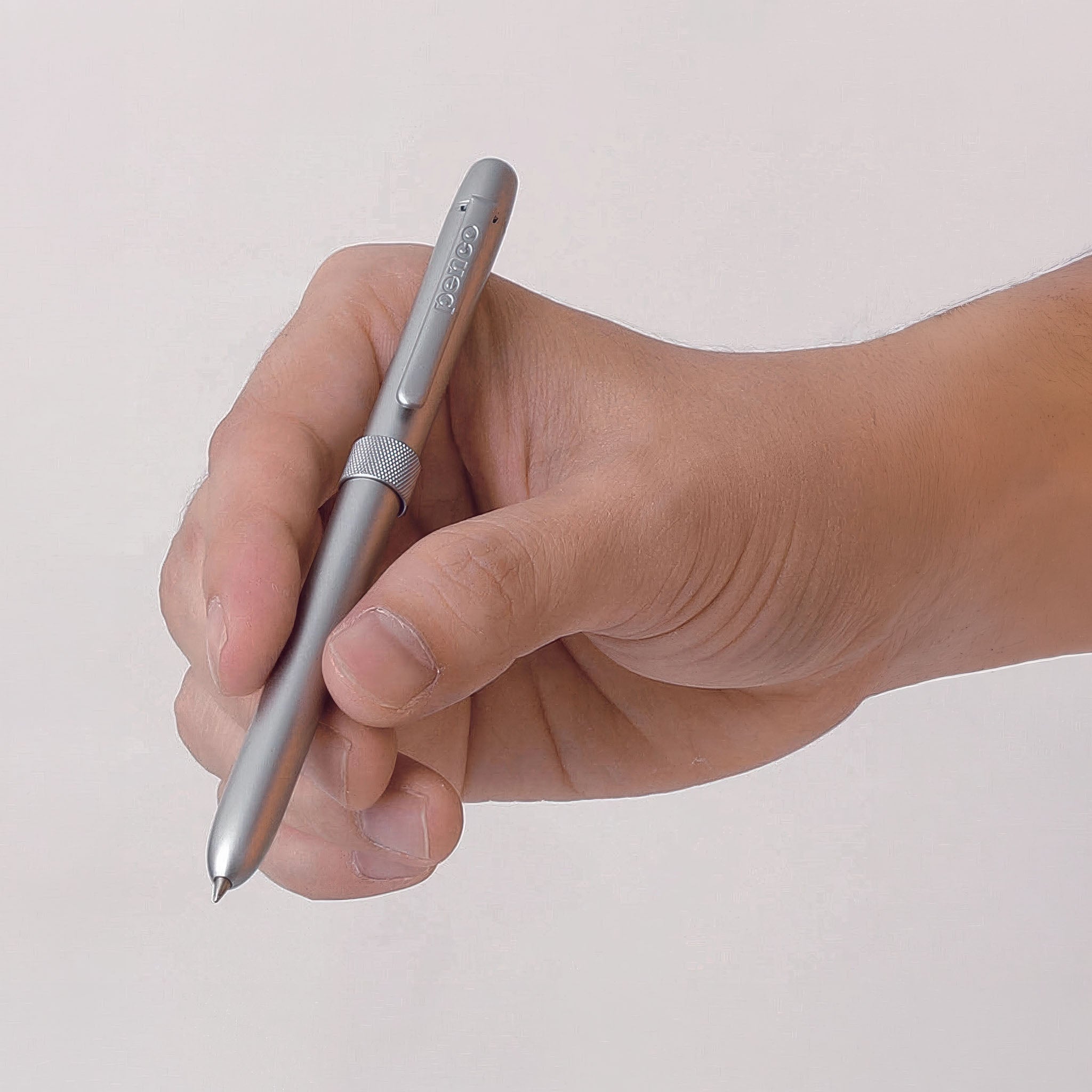 Hand holding a silver pen against a light background