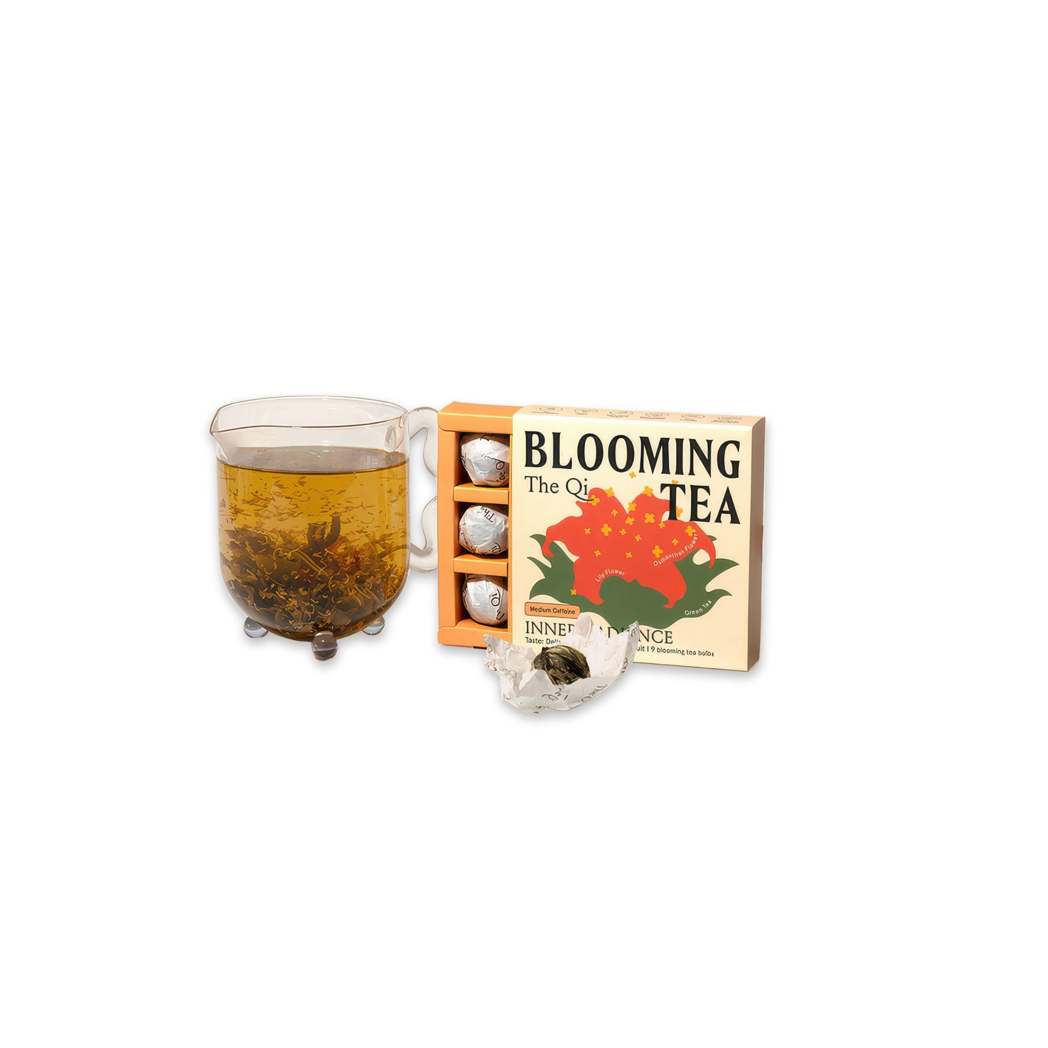 image of open box of the qi inner radiance blooming tea next to a tea pot