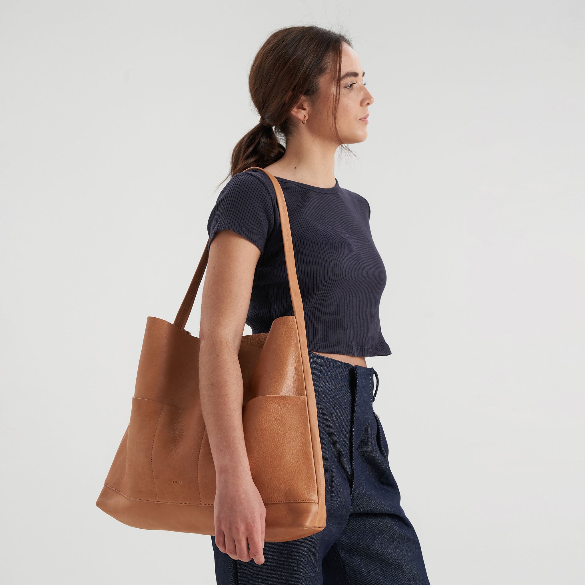 image of bonarda bag color saddle hanging on woman's shoulder