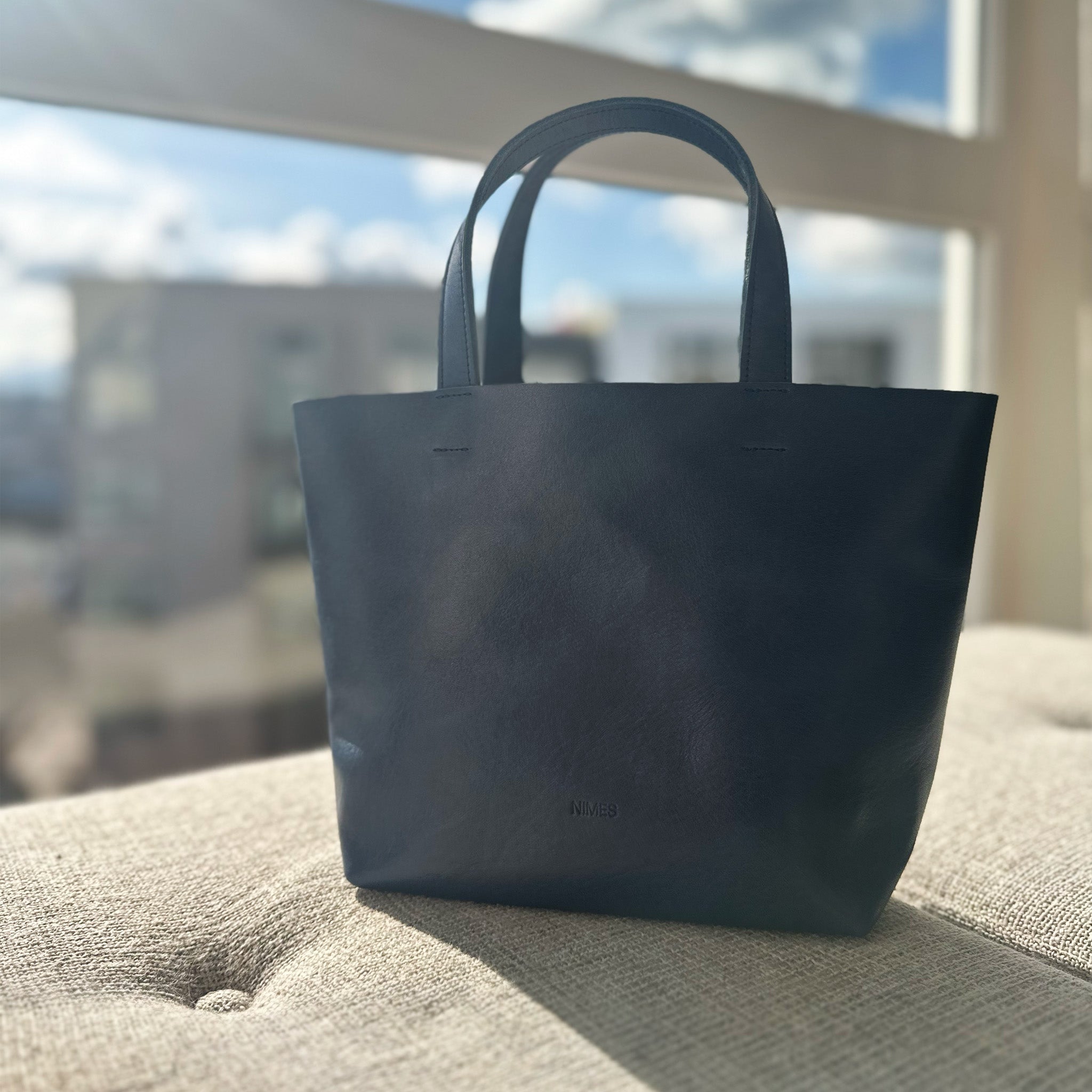 image of nimes gorriti bag navy color on cushion in sunlight