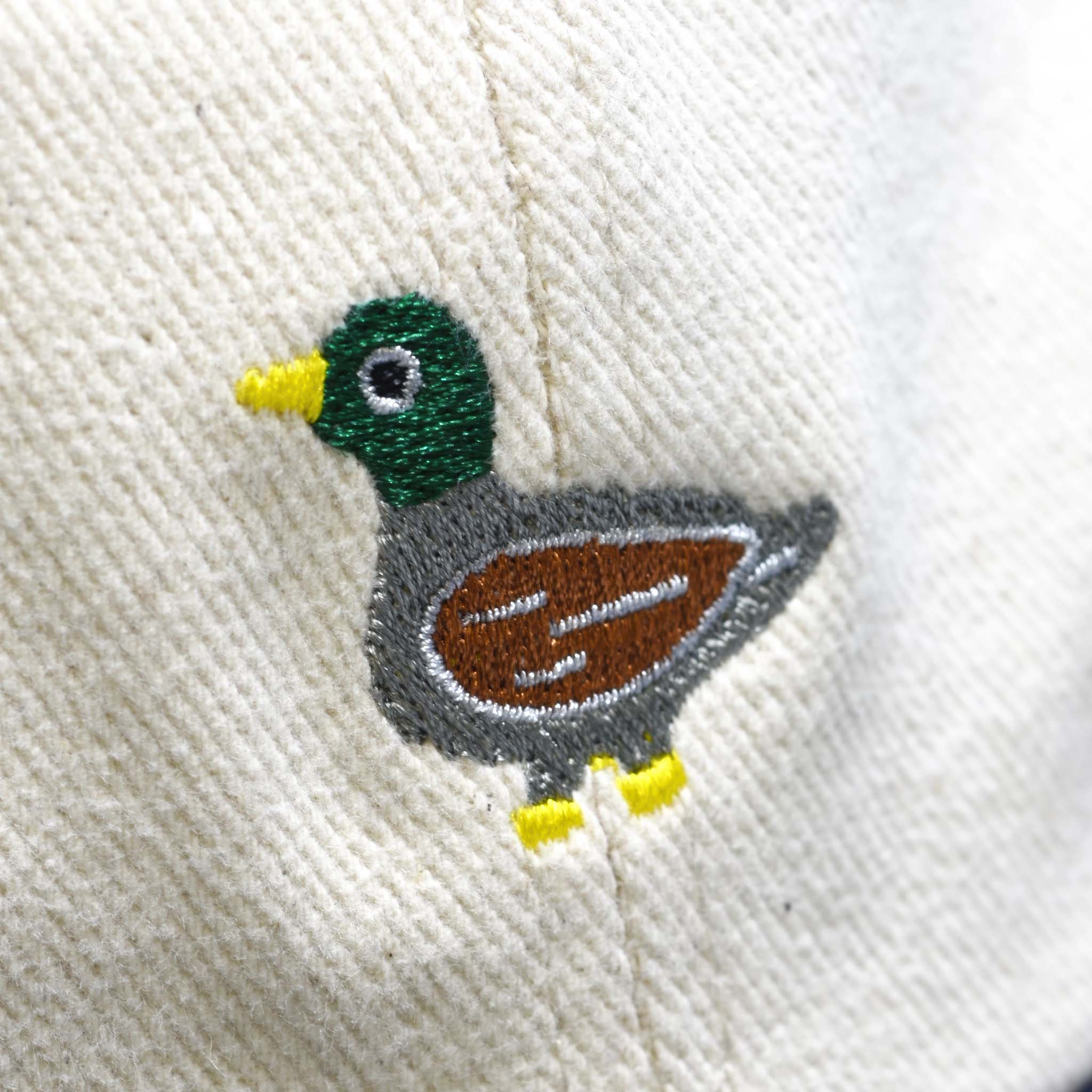 Embroidered duck design on a white fabric background