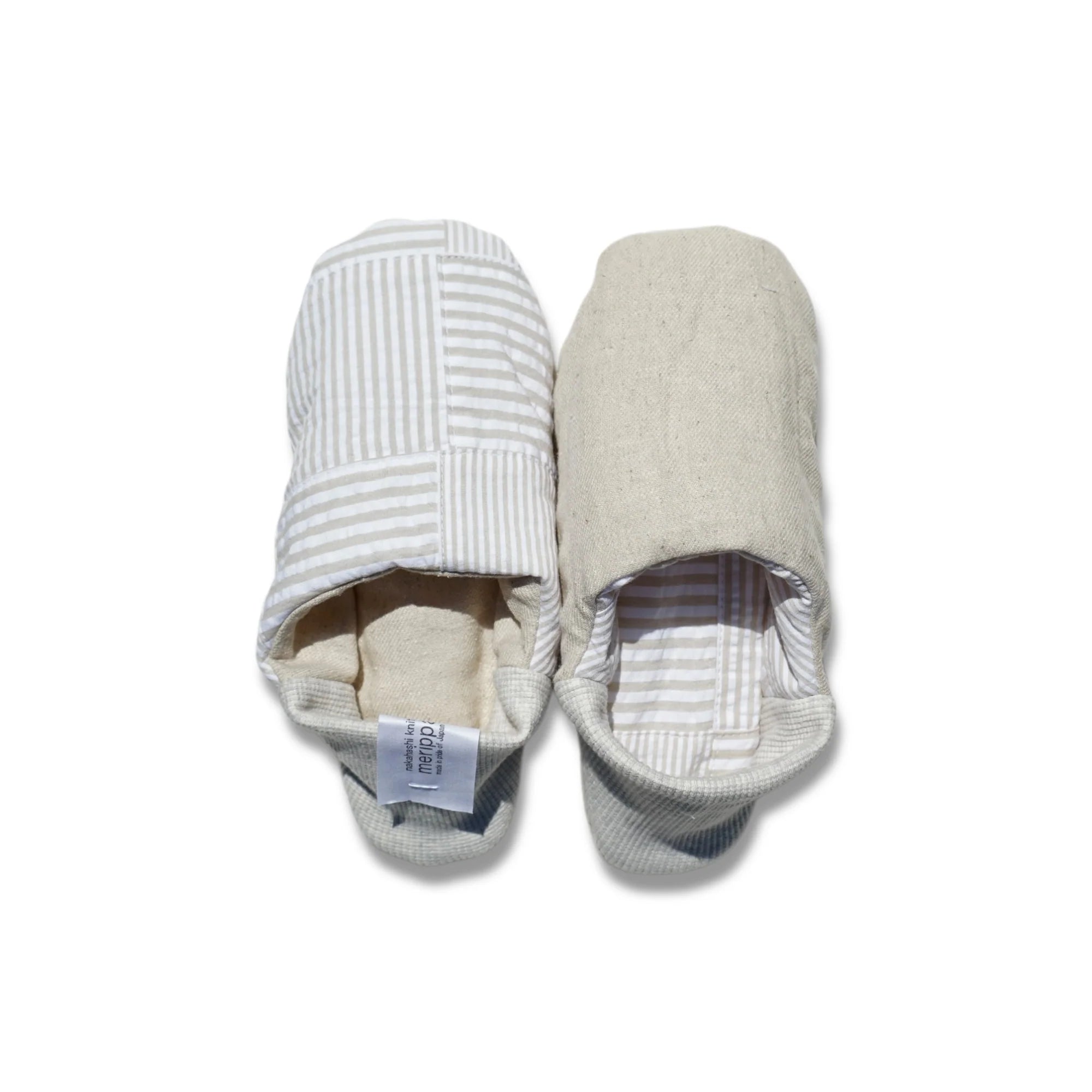 Pair of beige and white striped slippers on a white background