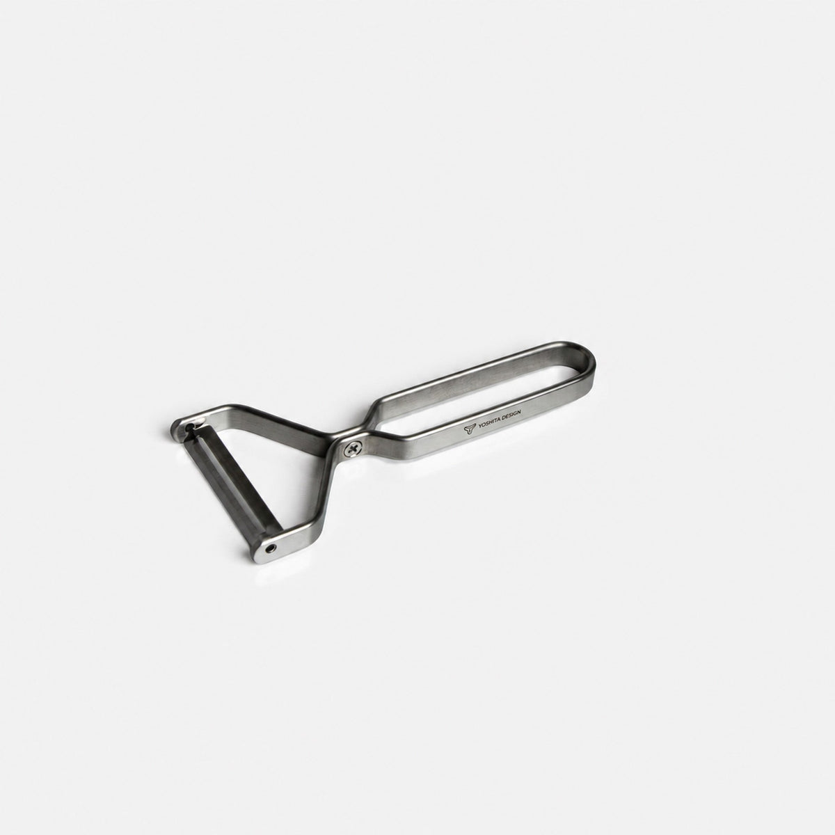 Yoshita stainless steel peeler on a light gray background