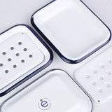 Aesthetic image of white soap dish with blue rim on a white background