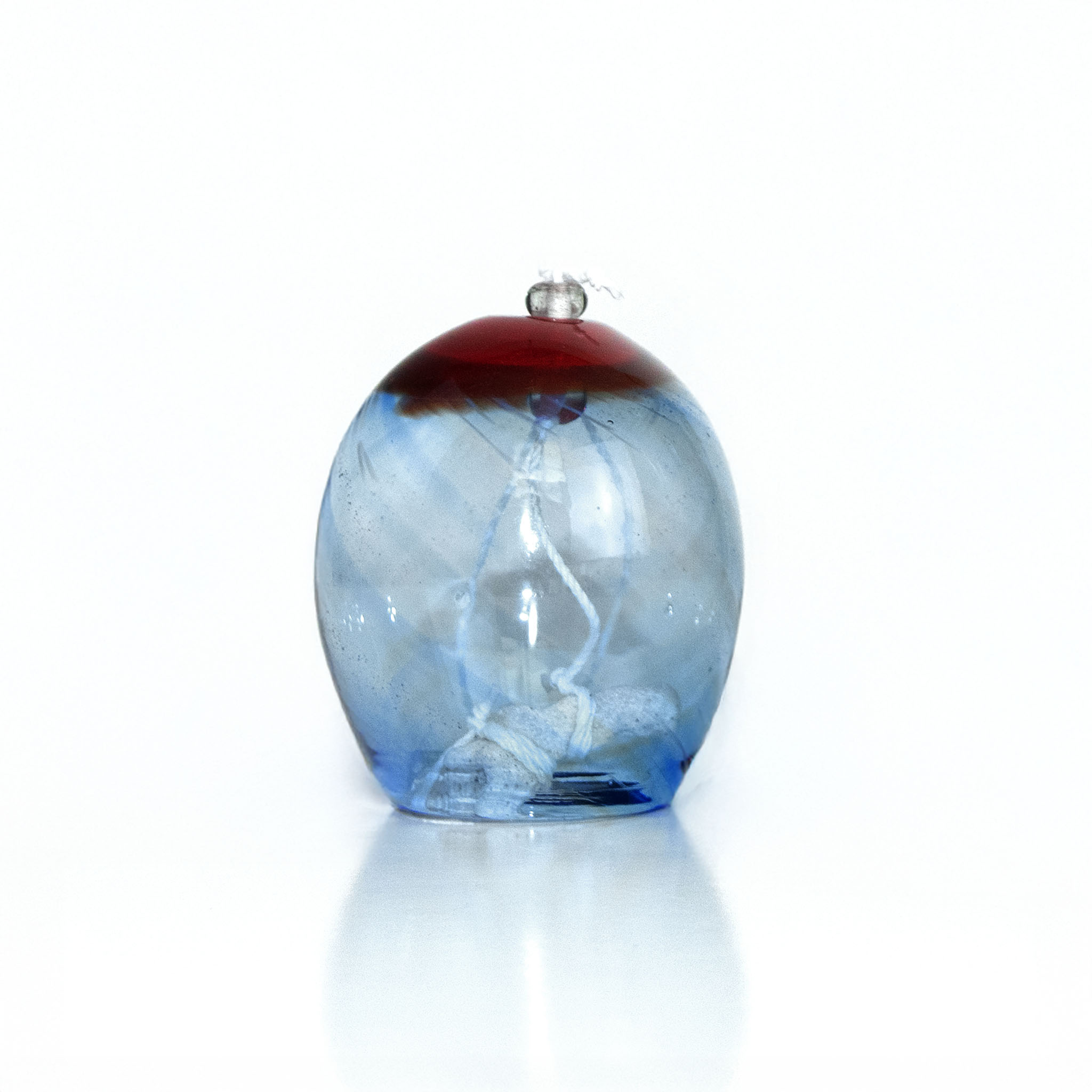 Blue glass wind chime with a red top on a white background