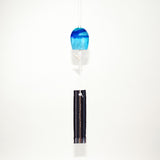 Blue glass Okinawan wind chime with black handwoven tab by Miyahira Studio, suspended on a white background.