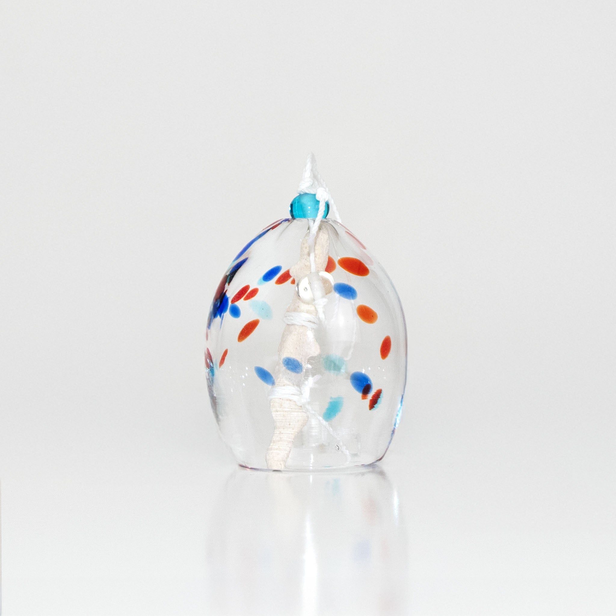 Colorful speckled glass wind chime on a white background