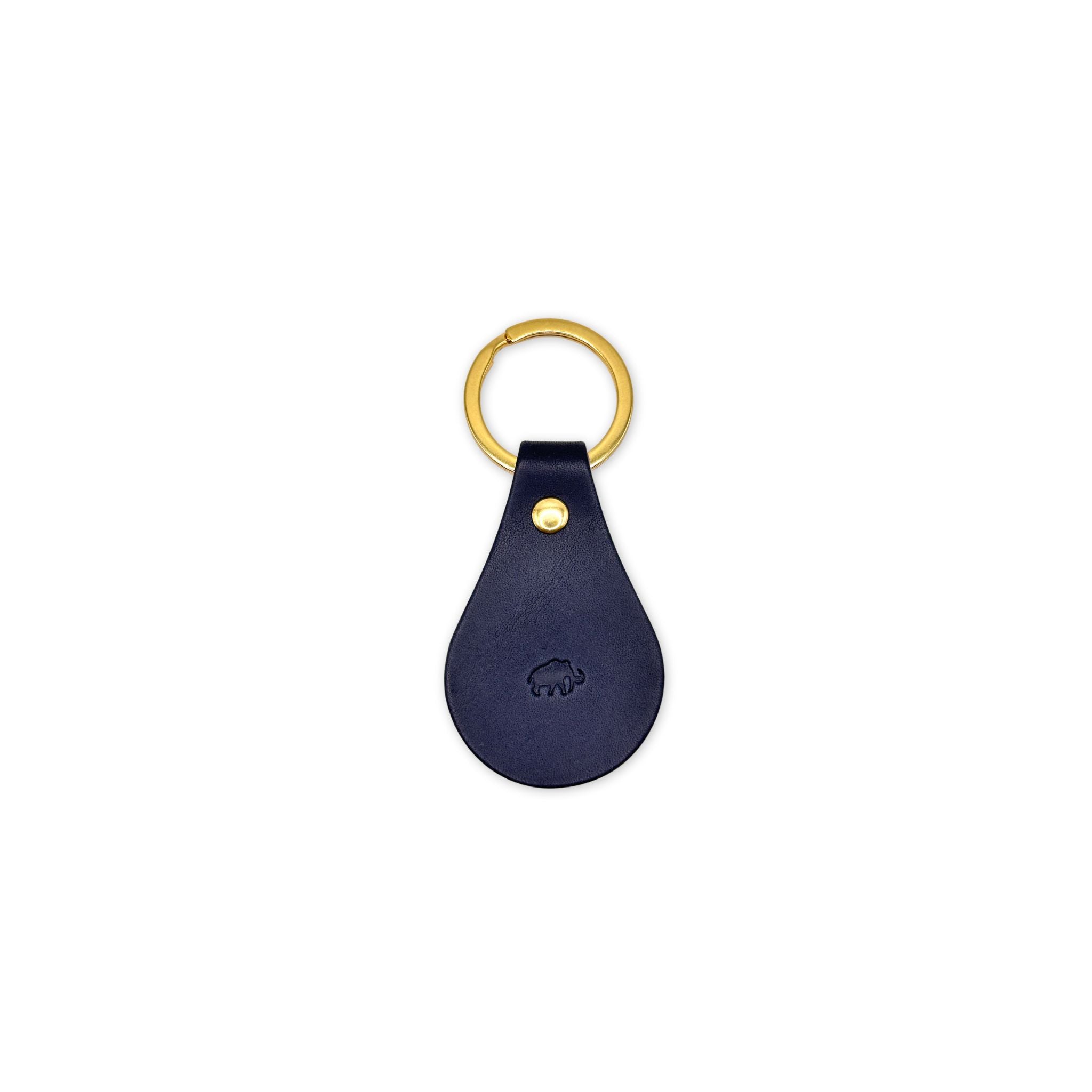 Navy blue leather keychain with gold ring and clasp on a white background