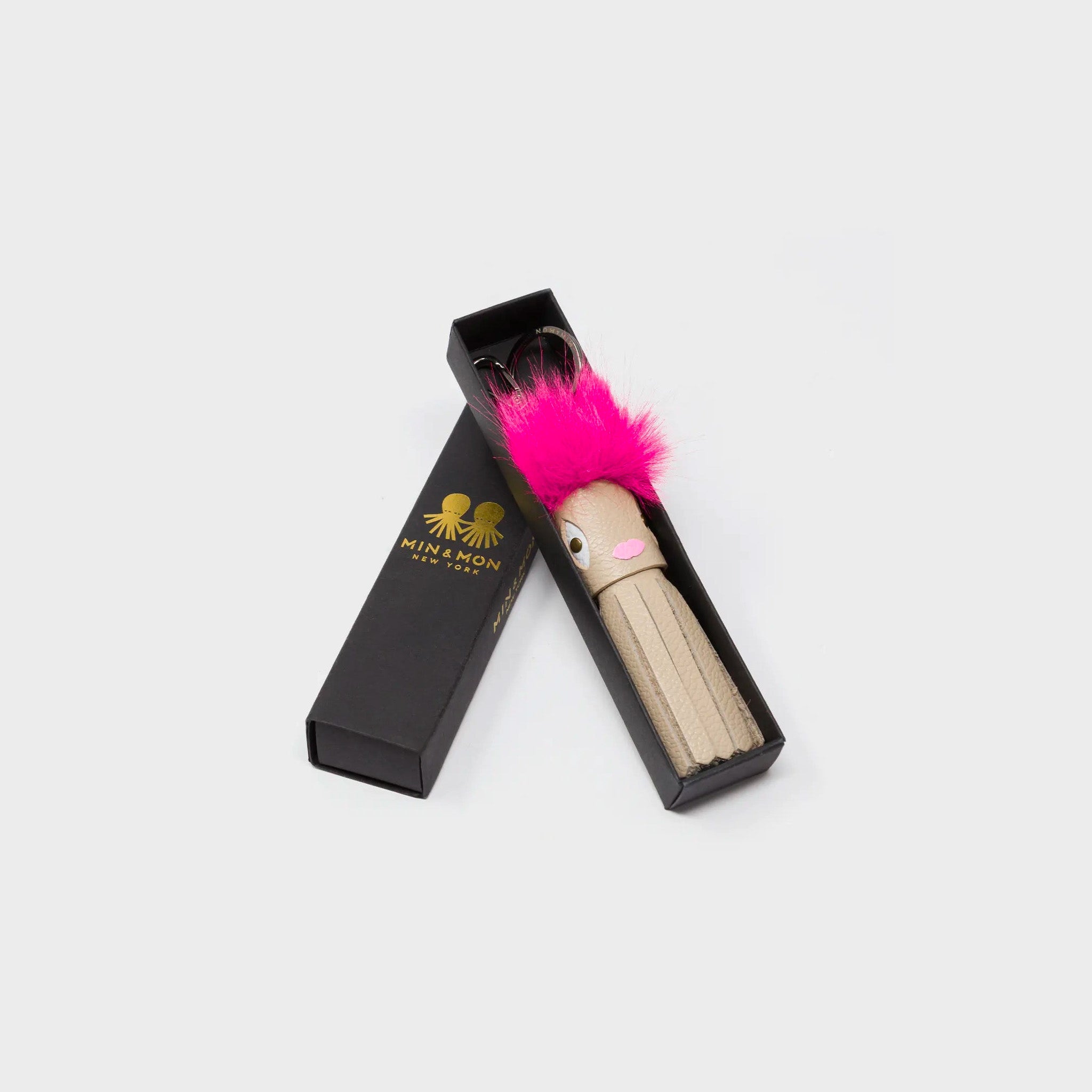 Min & Mon's Callie Marie Mayne - Beige Leather and Fucshia Faux Fur tassle in its retail packaging box on a white background