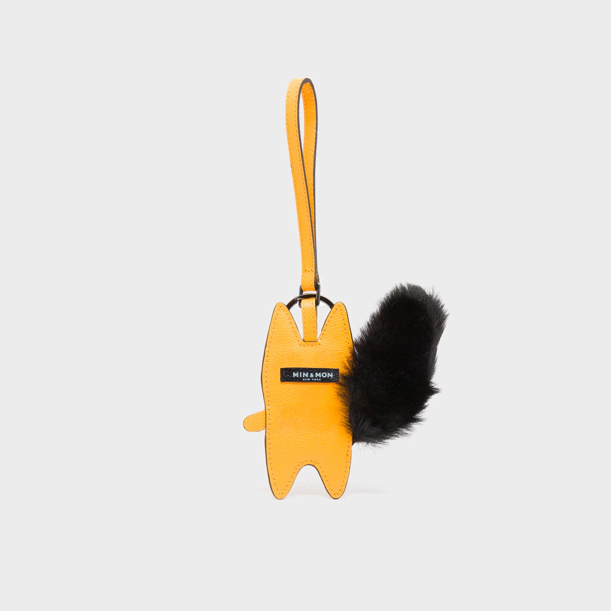 Back of Min & Mon's Flufftail - Black and Marigold Leather Bag Charm on a white background