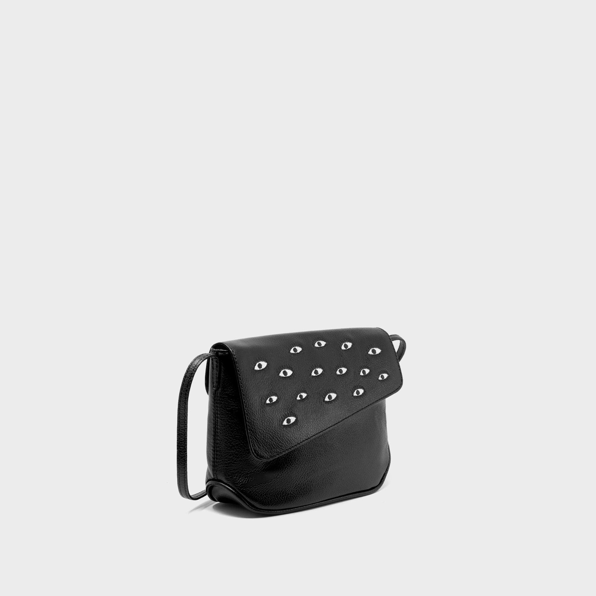 Black handbag with eye-shaped embroidery on a light gray background