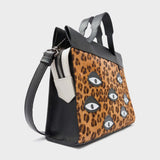 Angled view of Min & Mon's Vali Crossbody Small Animal Print Leather Bag - Eyes Applique Adjustable Handle