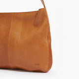 Close up of brown leather messenger bag on a white background