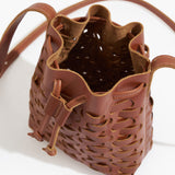Brown leather bucket bag with intricate cut-out design on a white background