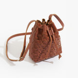 Brown leather drawstring bucket bag on a white background