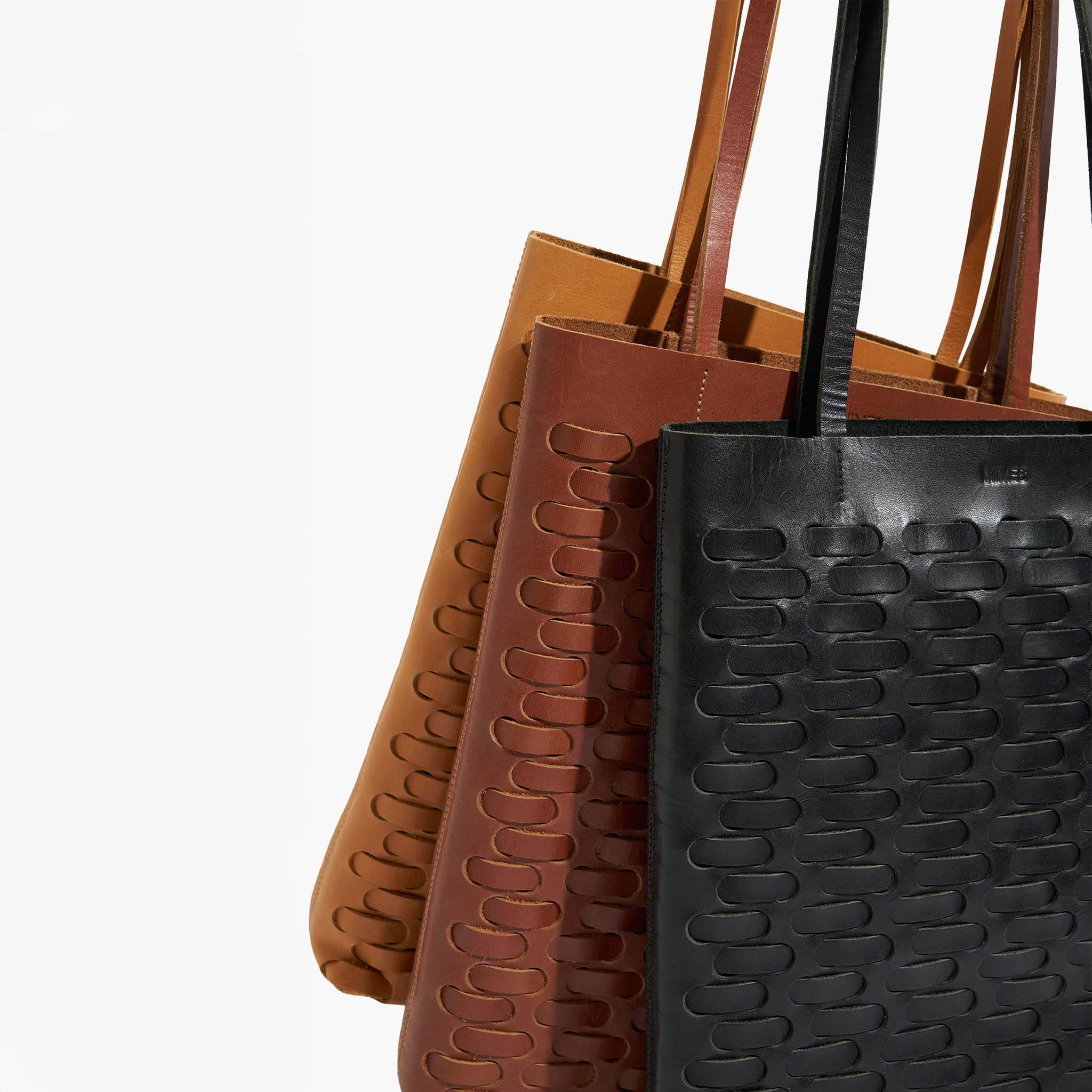 Three leather weave totes in brown, black, and tan on a white background