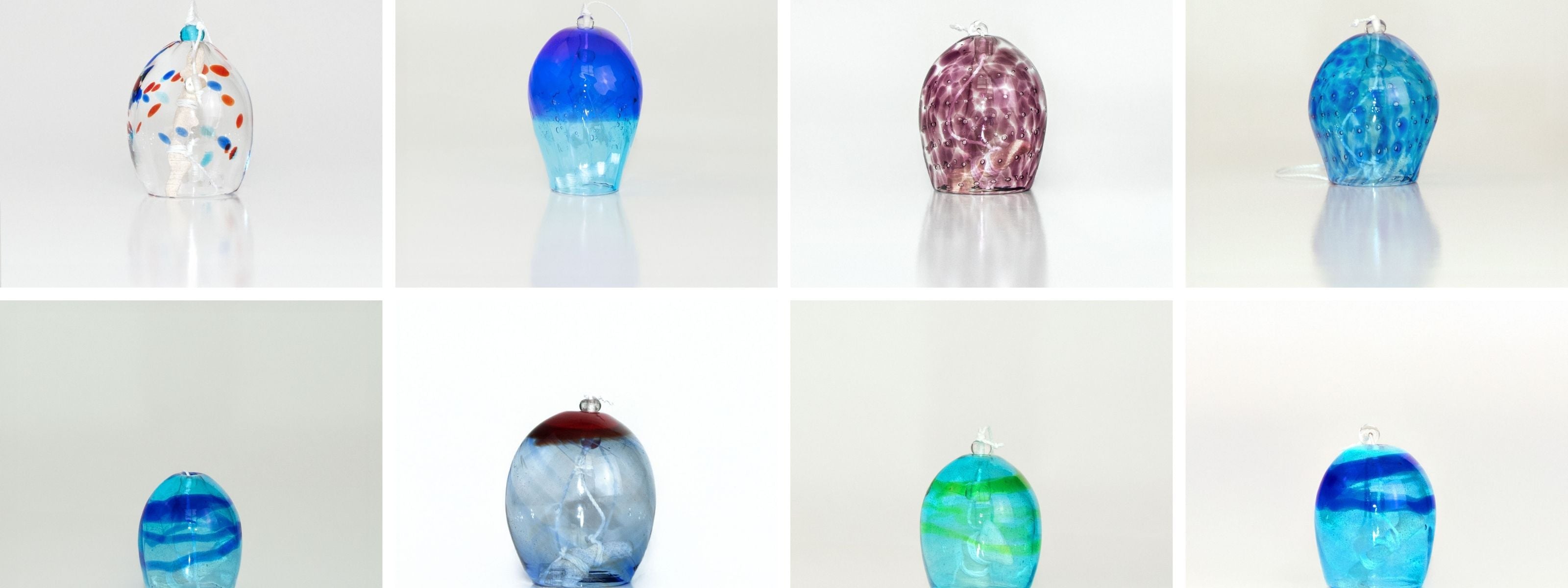 A grid of eight handcrafted glass wind chimes from the Umikaze collection, each uniquely shaped and colored in translucent shades of blue, aqua, and violet, with patterns inspired by ocean waves and island breezes.