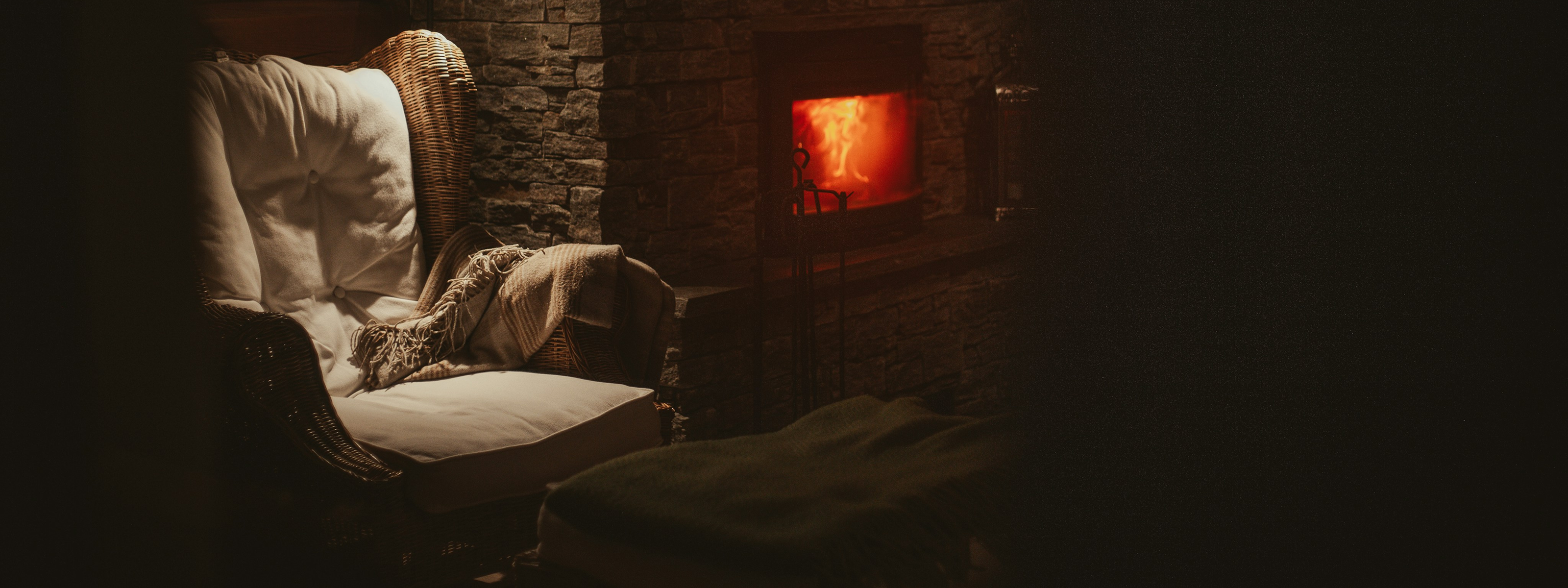 Cozy room with a lit fireplace and armchair.