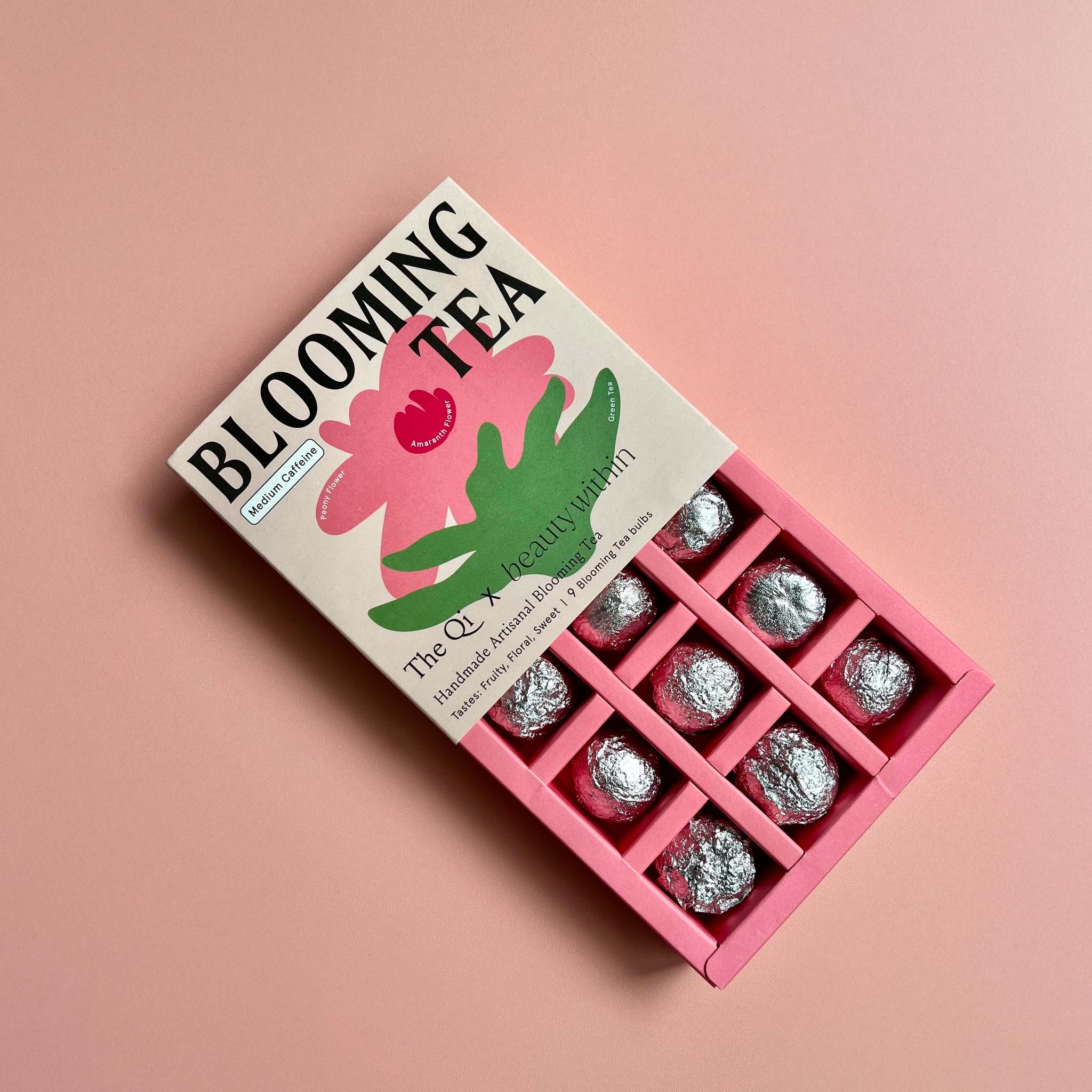 Box of Blooming Tea opened w bulbs wrapped on a pink background