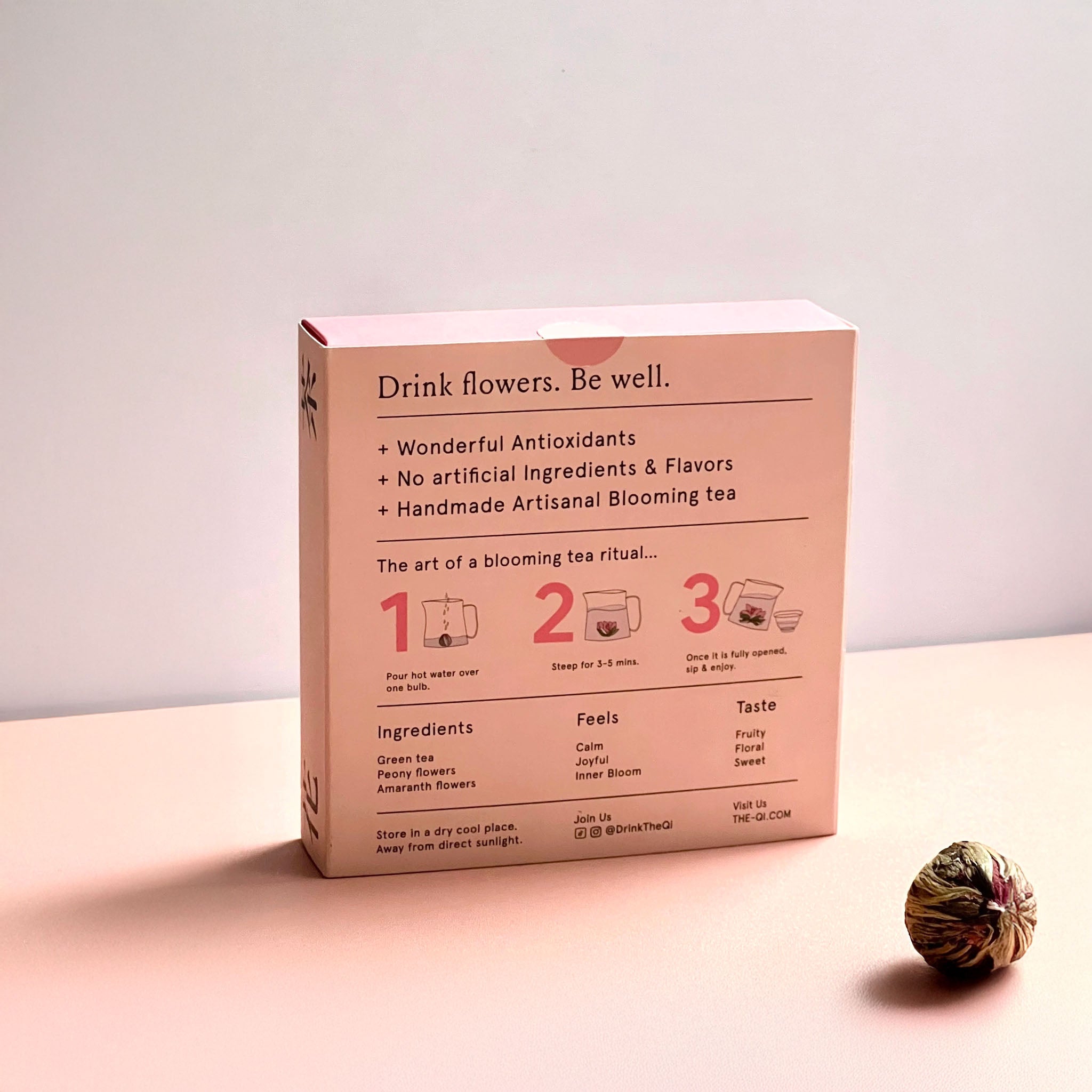 Box of blooming tea with instructions on a light pink background