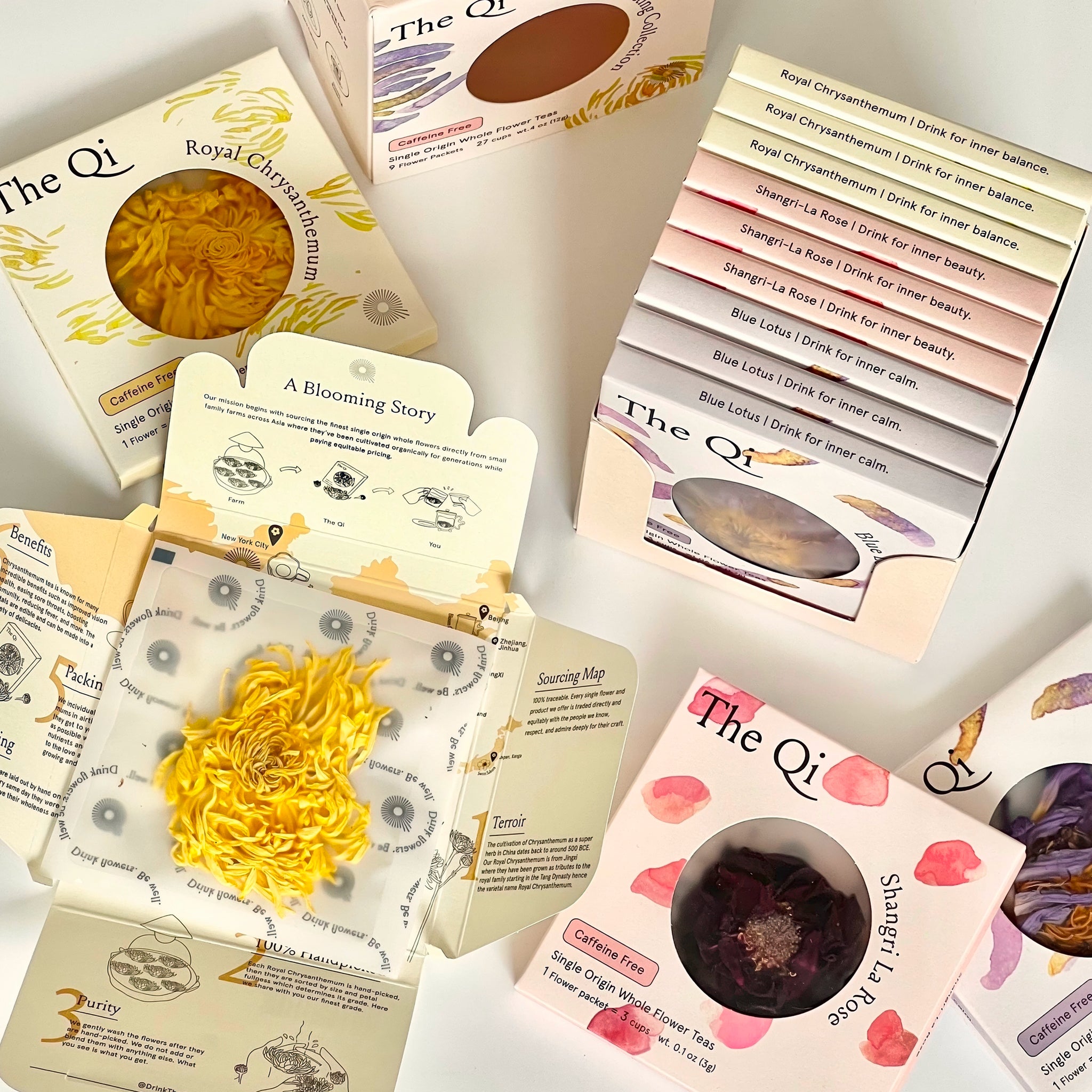 Collection of 'The Qi' product packages with various herbs and packaging designs.