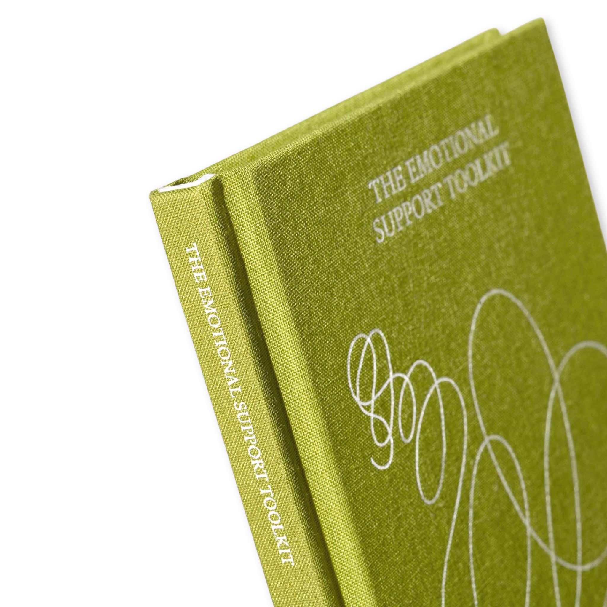 Green notebook titled 'The Emotional Support Toolkit' on a white background