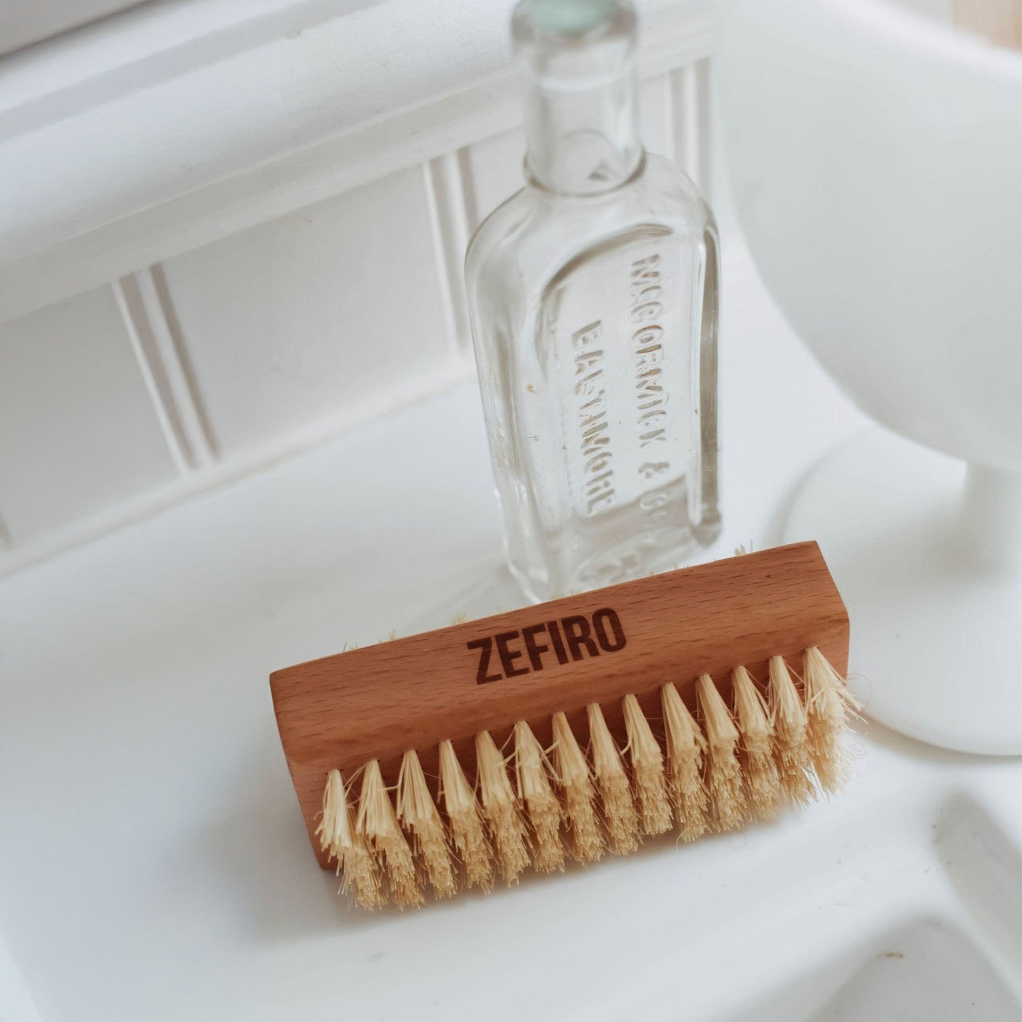 Wooden brush with bristles and 'Zefiro' branding on a white surface.