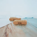 Two wooden brushes with bristle heads on a marble surface, branded 'Zefiro'.