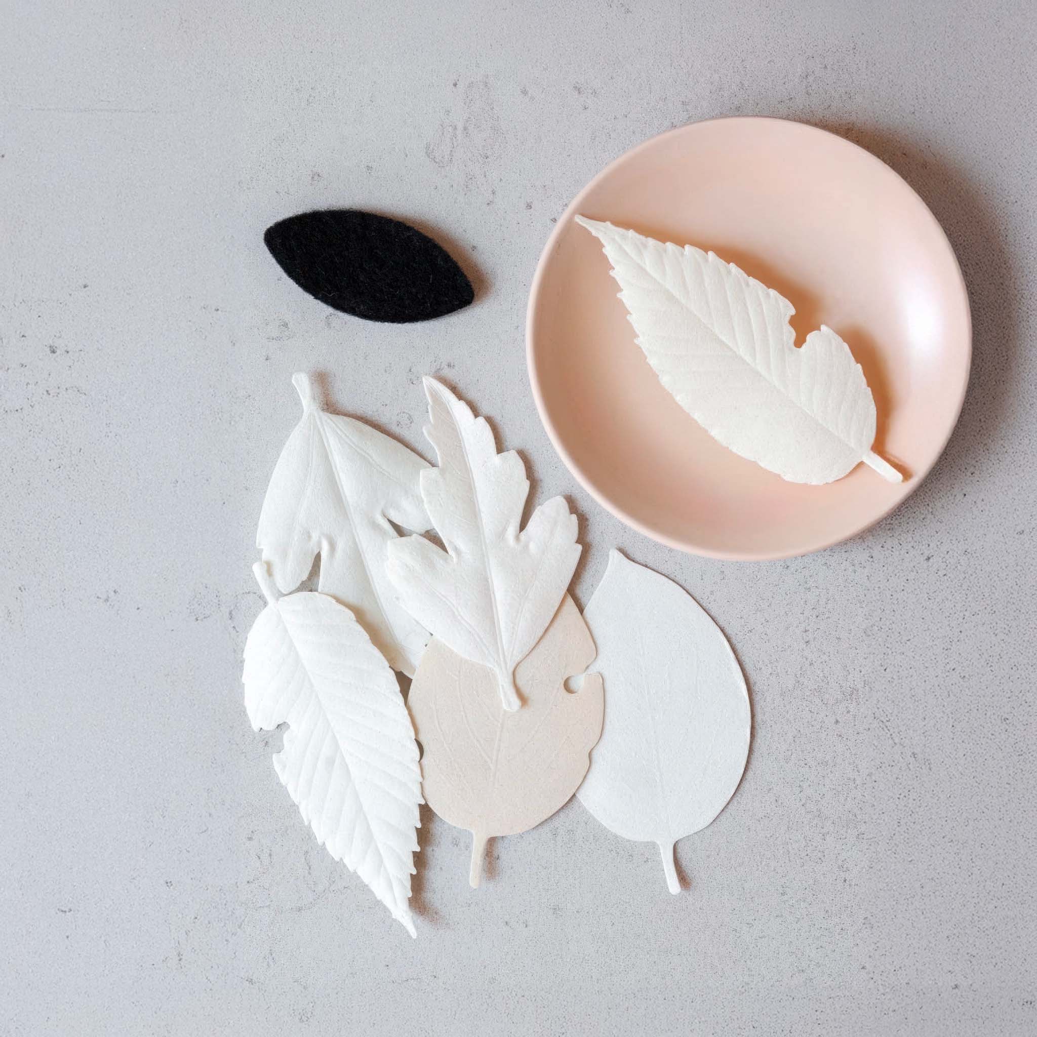 Ha Ko leaf-shaped incense items from the kit on a gray surface with a pink plate.