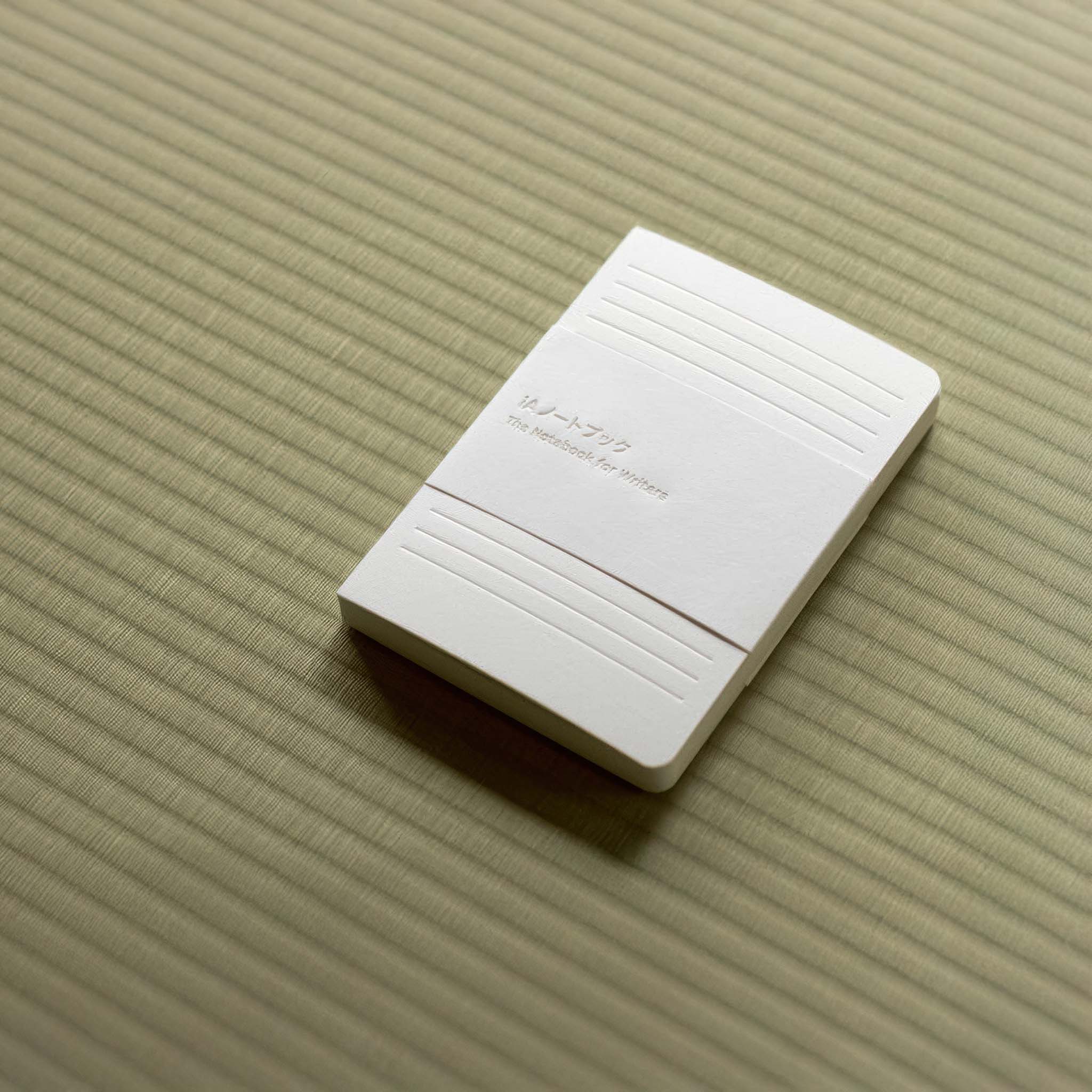 White iA notebook for writers on a textured tatami surface.
