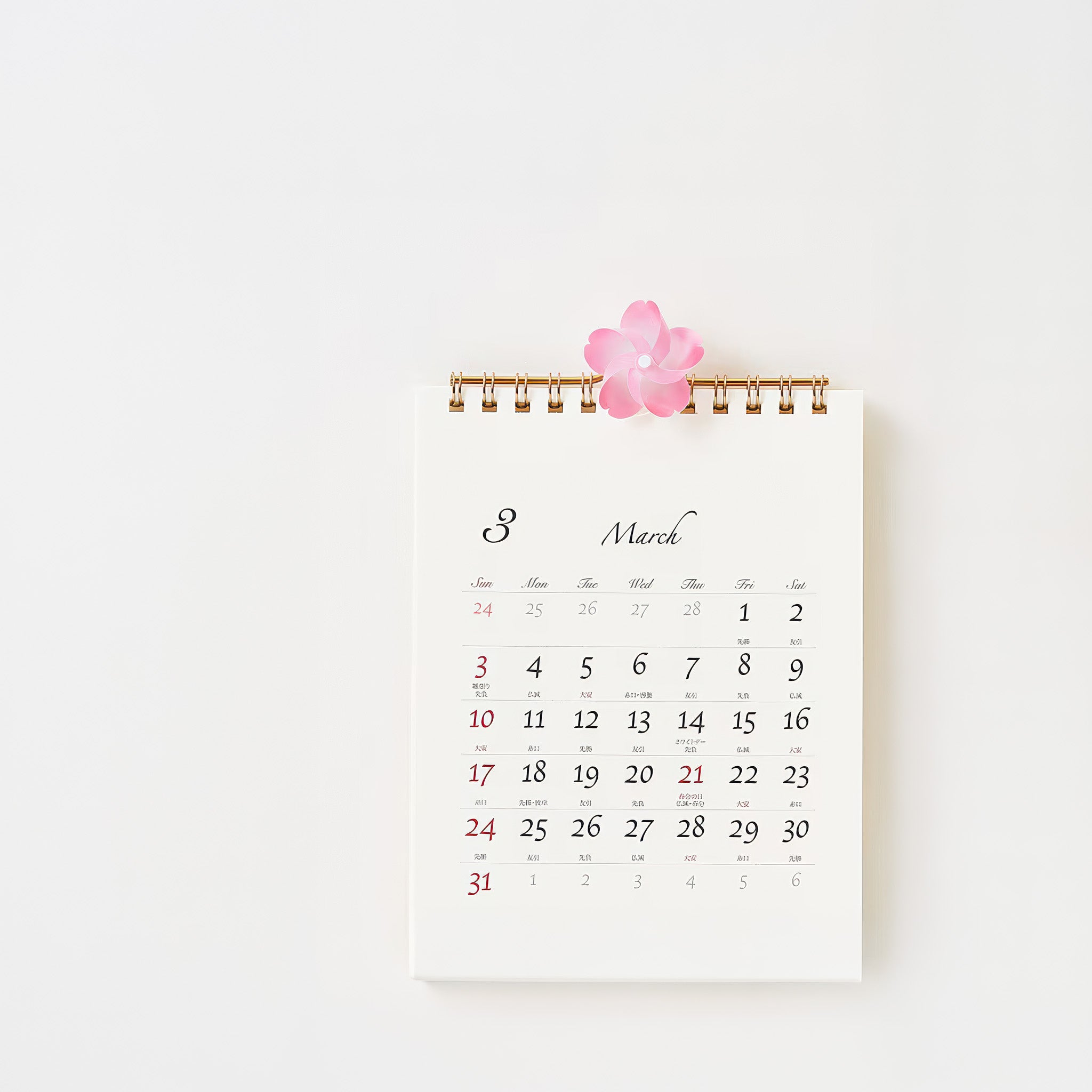 A cherry blossom pinwheel adorning a calendar with March on a white background