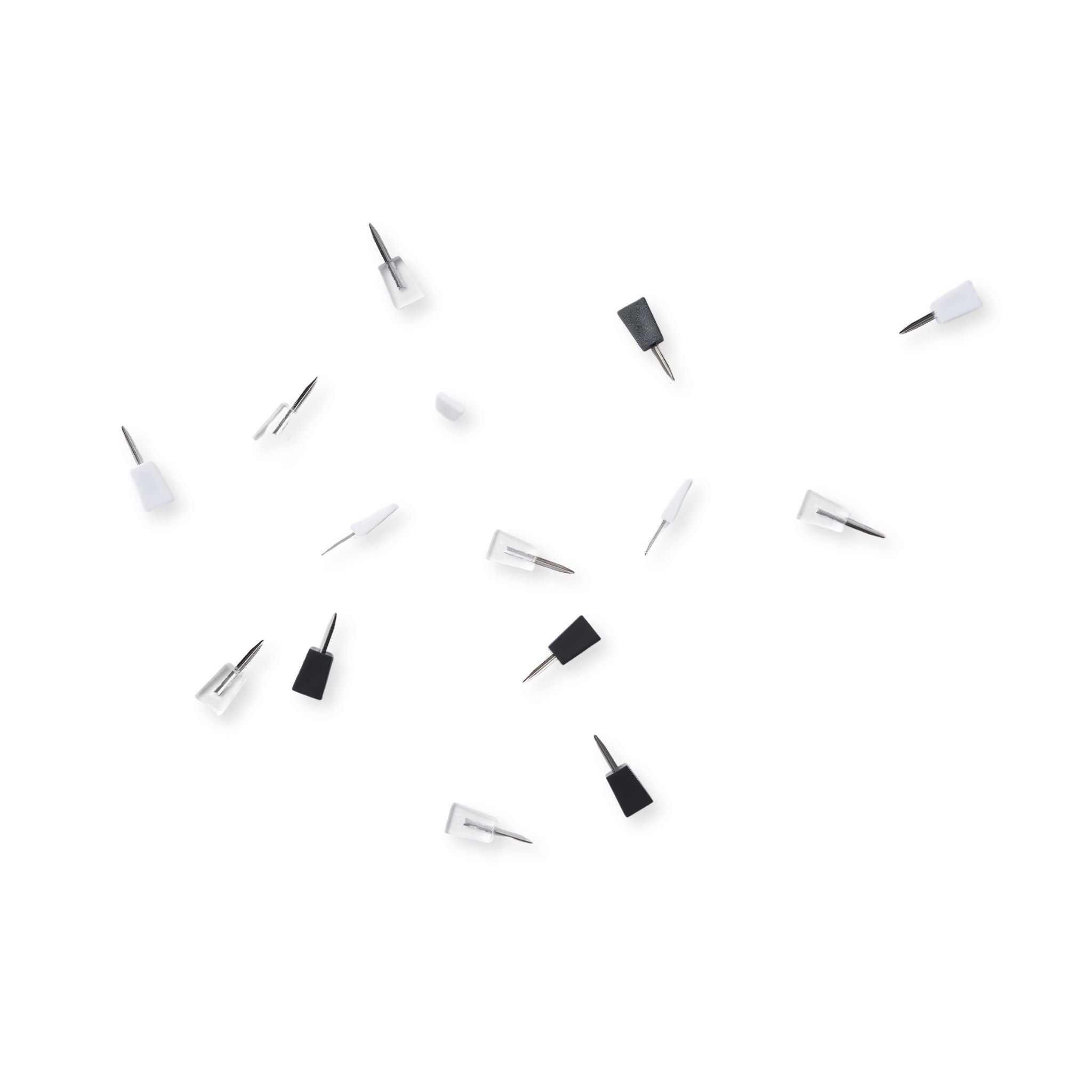 A collection of white, clear and black ninja mini pins scattered on a white background