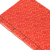 Red notebook with a gold pattern on a white background