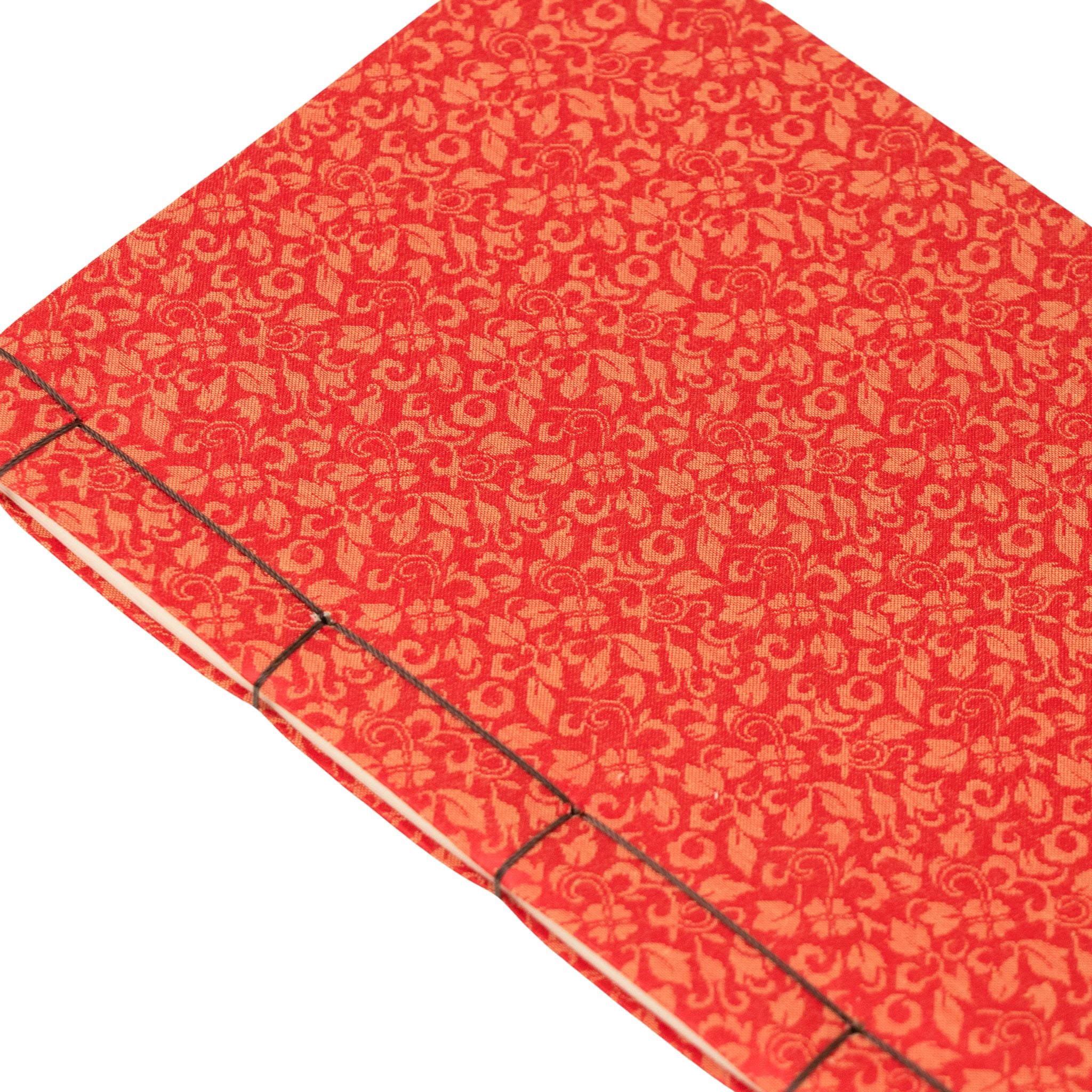 Red notebook with a gold pattern on a white background
